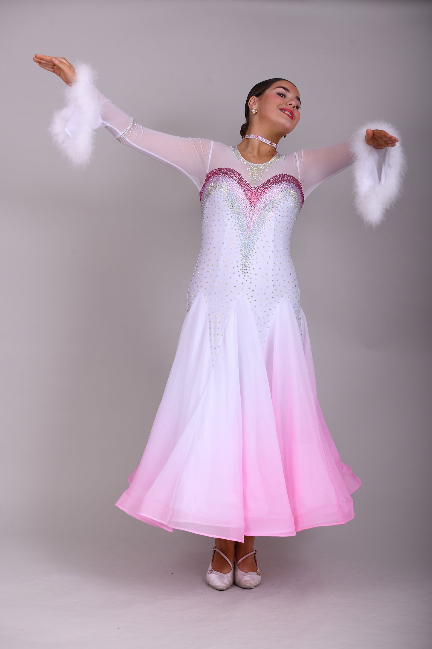 207 Pale Pink & White Ombré Ballroom Dress. Scoop neck & High mesh back. Feature stoning at the chest in rose, light rose & AB. Feather detailing to bell sleeves.