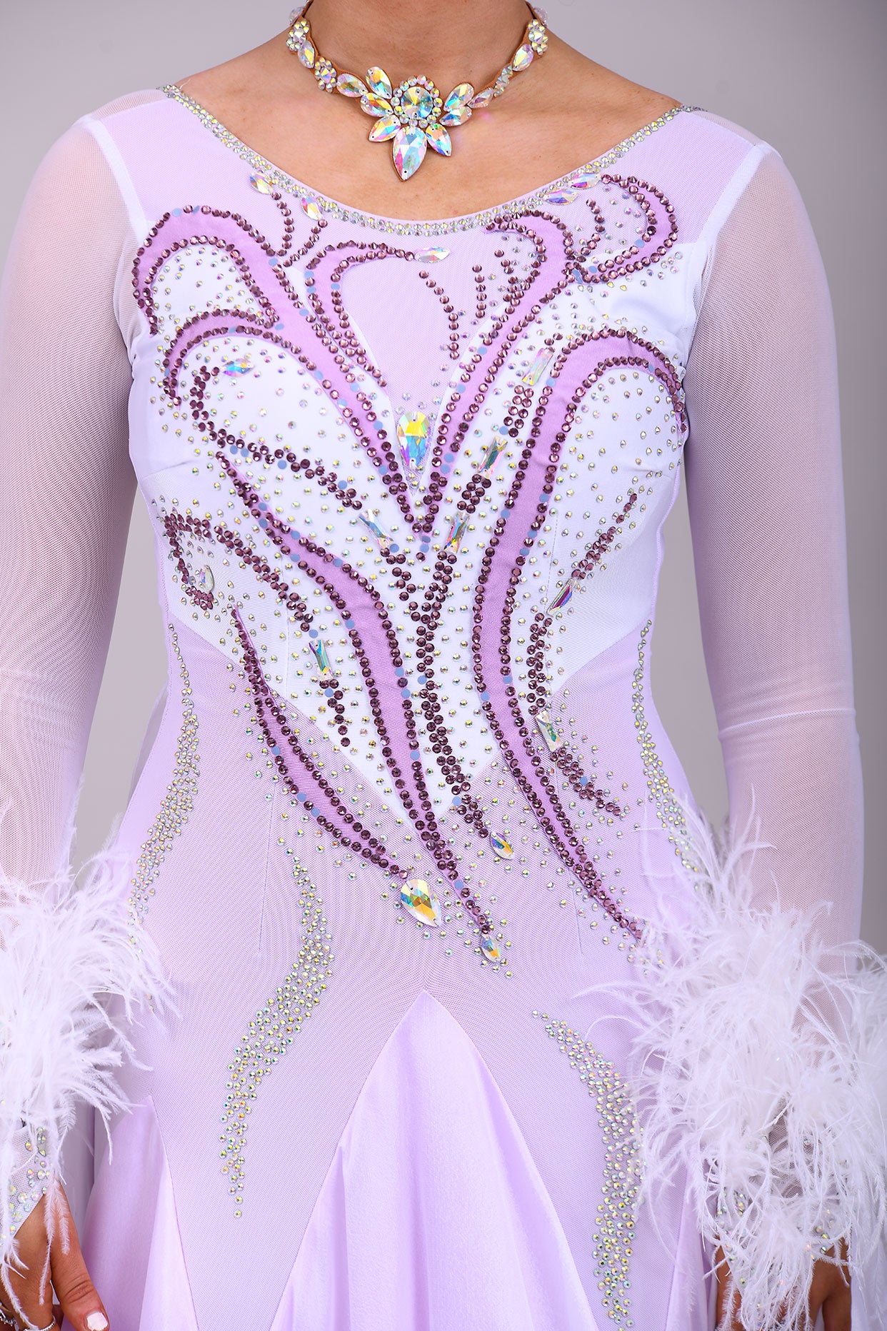 233 White Dress with lilac underlayer to the skirt. White floats. Decorated in lilac & AB stones with ostrich feather detail to the cuffs