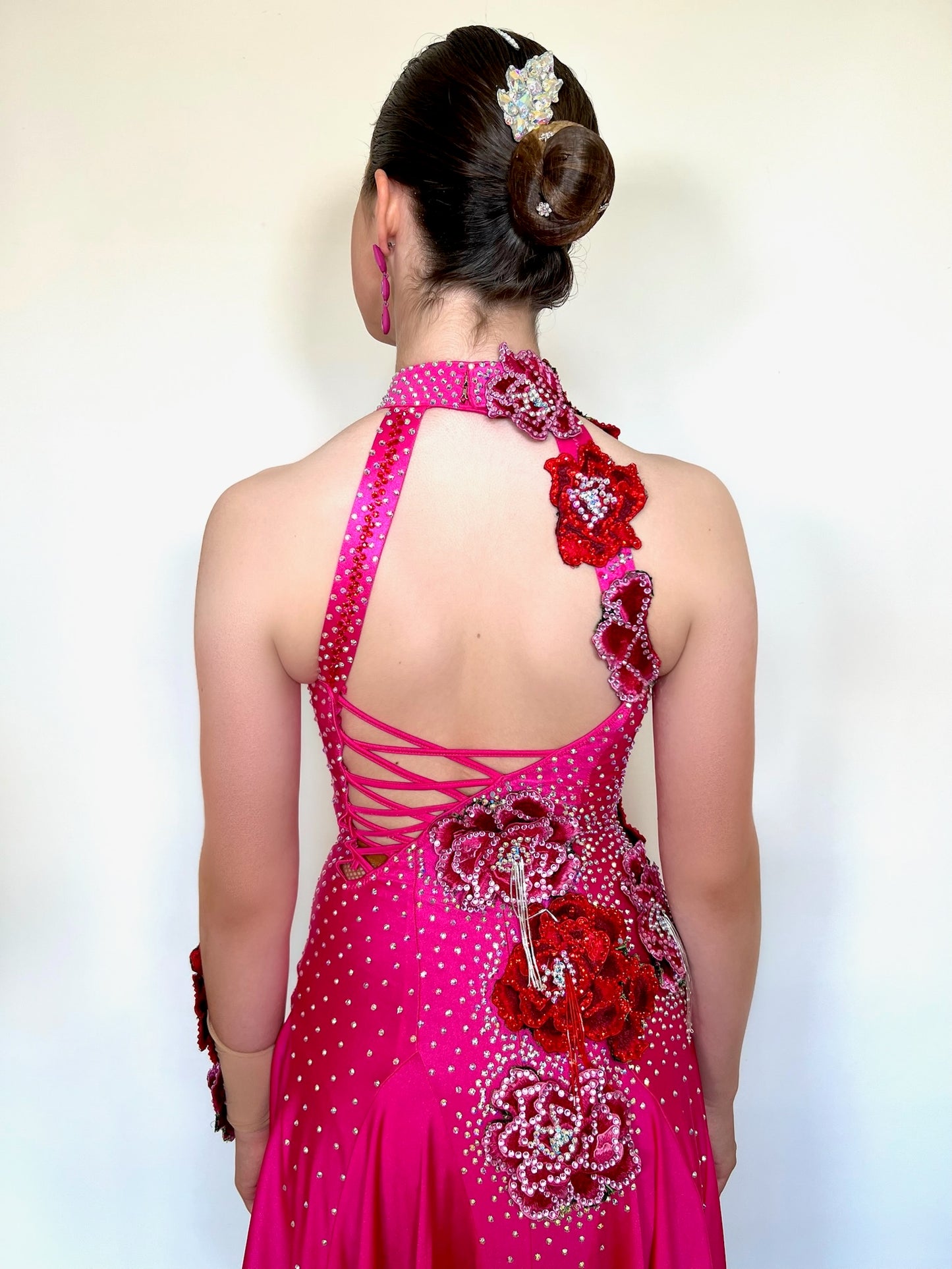 018 Magenta Halter neck style Latin dress. Shaped skirt with side split. 3D flower decorations to the front & back of bodice. Flowers to wrist cuff.