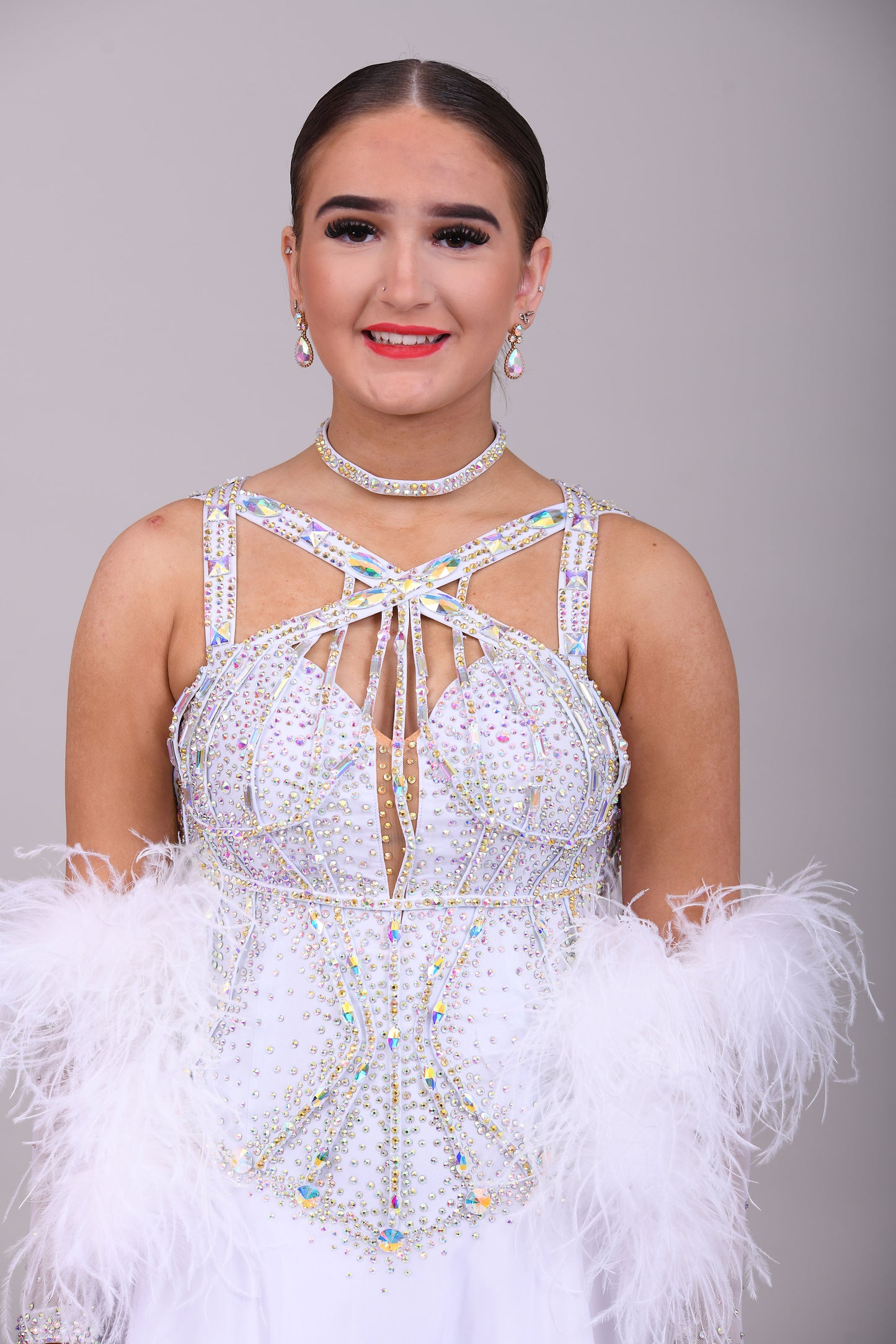 013 White Competition Ballroom/Sequence Dance Dress. Striking detailing to both the front & Back. Stoned in AB and sunshine. Cones with gloves, floats & Ostrich Boa cuffs.
