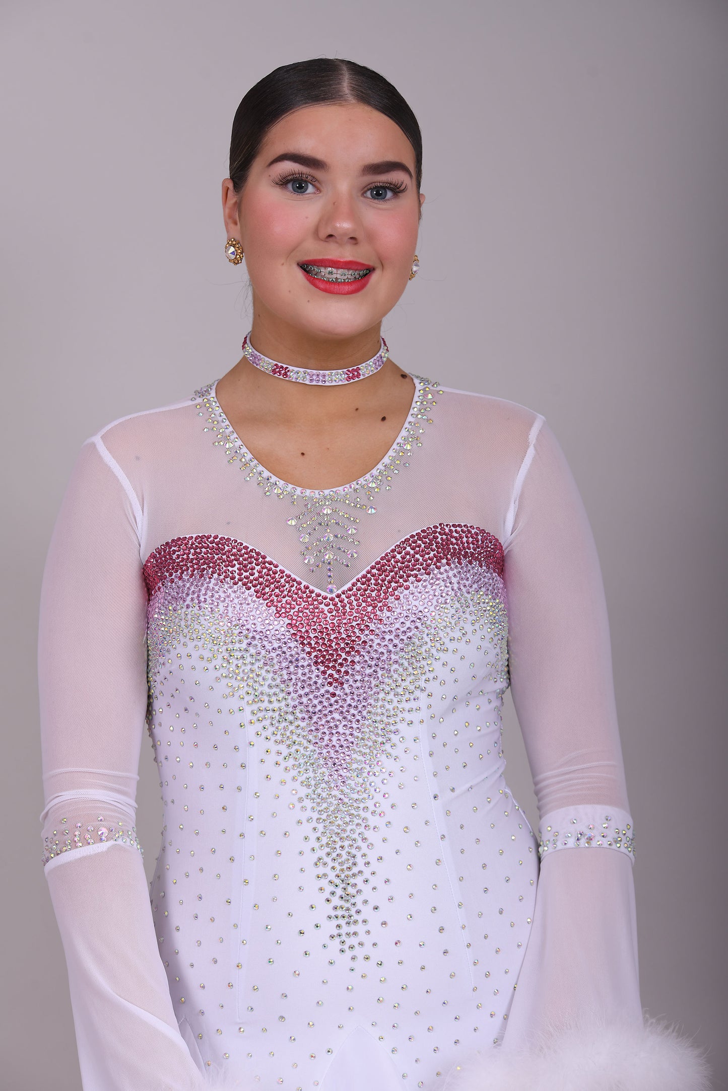 207 Pale Pink & White Ombré Ballroom Dress. Scoop neck & High mesh back. Feature stoning at the chest in rose, light rose & AB. Feather detailing to bell sleeves.