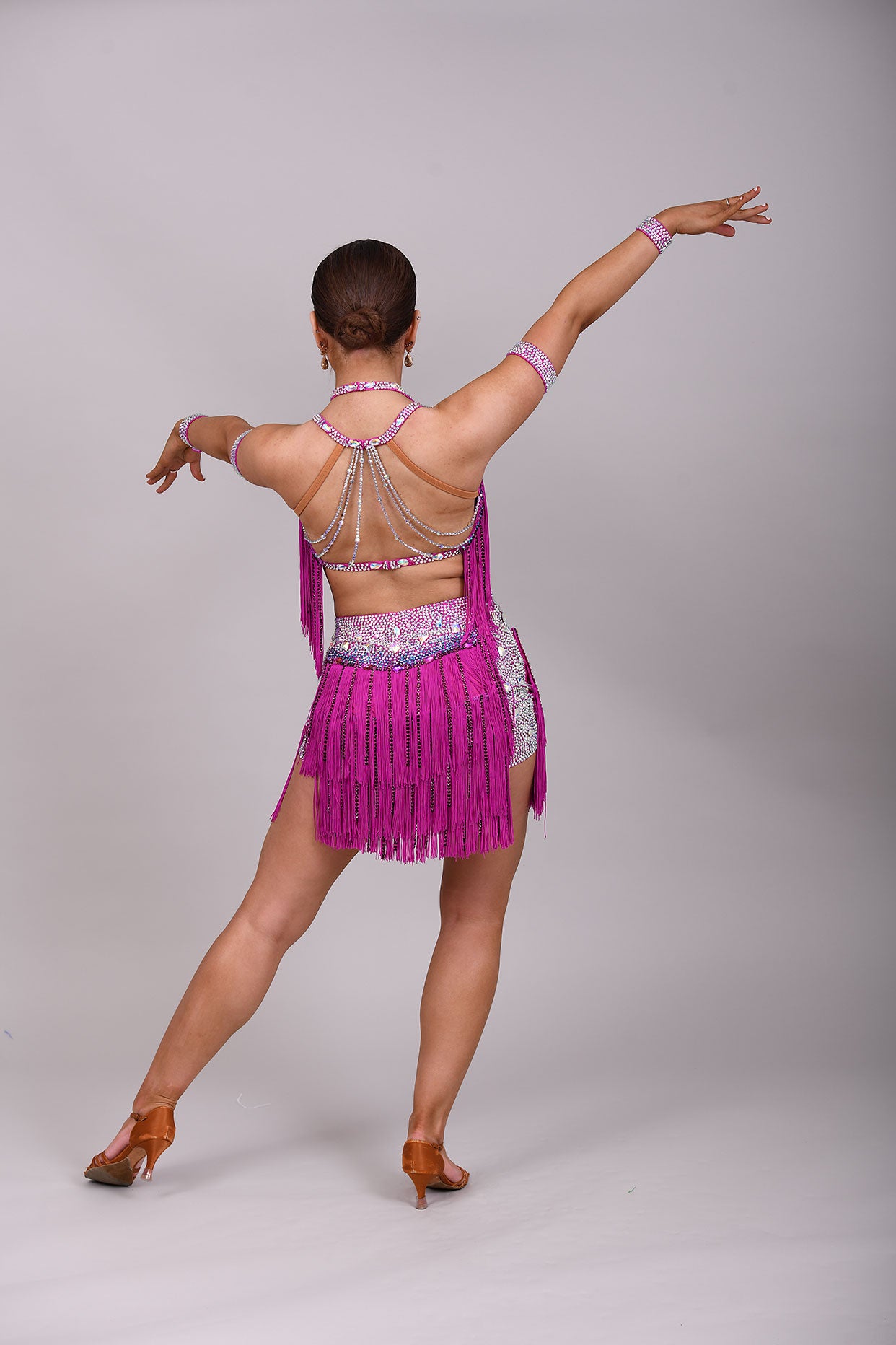 184 Fuschia Pink Latin 2 Piece. Very full fringed skirt and top. Stoned in Amethyst, AB & Aquamarine AB. Shorts attached under skirt