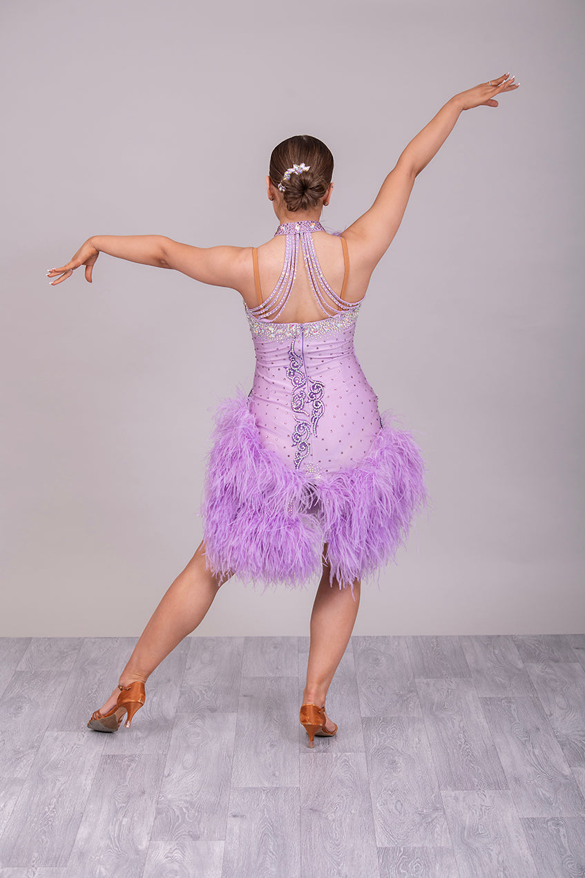 344 Lilac Latin Dress with keyhole halter neck detail. Strapping design on back. Lilac ostrich feather boa skirt. Decorated with purple motif. Stoned in green & AB Boa is hand stitched so could be rearranged