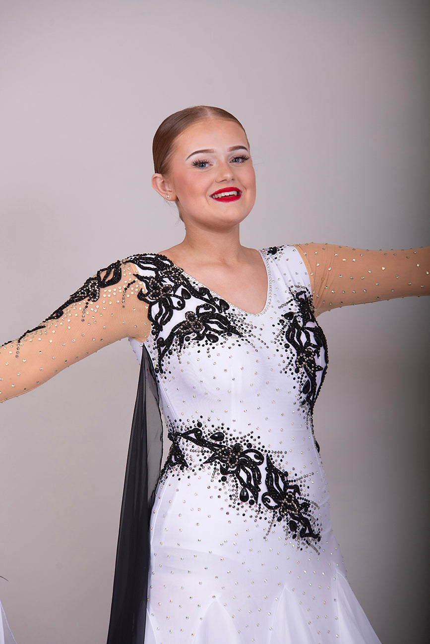 048 White Ballroom Dress with Black lace detailing to the upper chest & sides. Comes with x2 cuffs decorated with appliqué. Stoned in AB and Jet