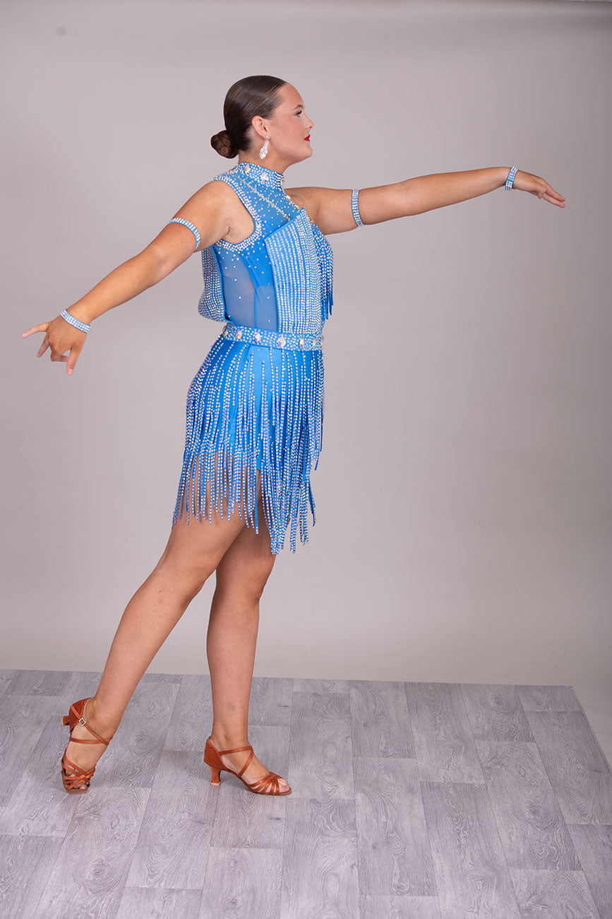 134L BUDGET (24) Blue Competition Latin Dance Dress. Stoned fabric strip detail throughout with 3D feature yo upper chest. Stoned in AB ❤️Showroom Appointments Available❤️