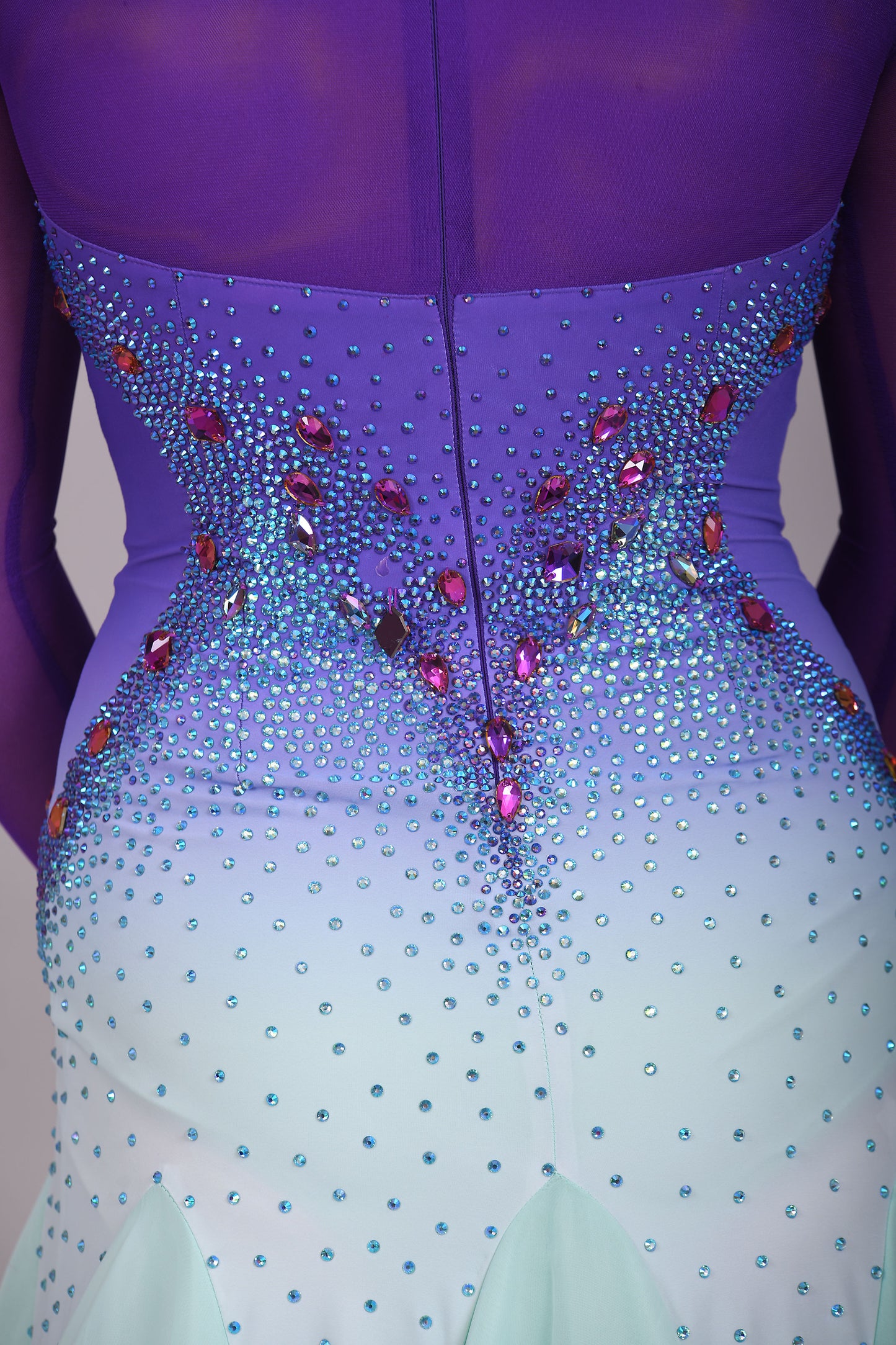 167 Ombré purple to mint green competition Ballroom dance dress. Stoned in mint green, mint green ab, purple & vitrail. Ostrich feather floats attached to stoned strips. High back to give the option of wearing own bra.