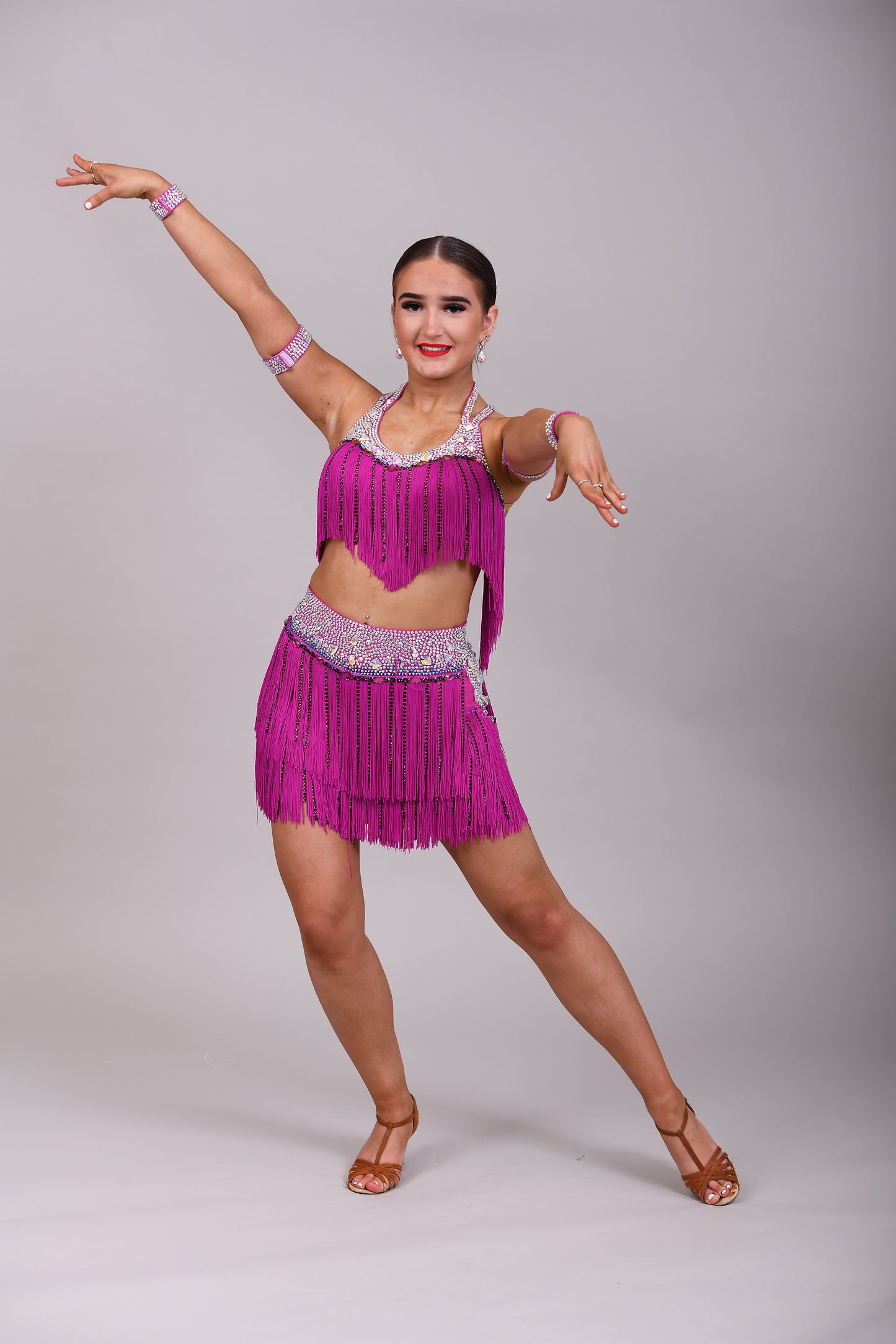 184 Fuschia Pink Latin 2 Piece. Very full fringed skirt and top. Stoned in Amethyst, AB & Aquamarine AB. Shorts attached under skirt