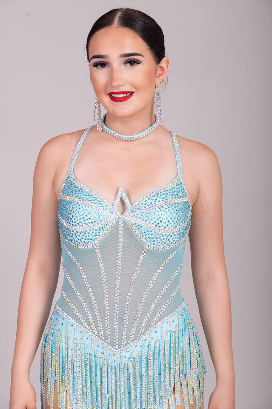 30L Standout Pale Aqua Competition Latin Dance dress. Beautiful front detailing with Aqua mesh centre with corset effect stoning. Heavy stoned fabric tassels to the skirt. Crossover strapping on the back.