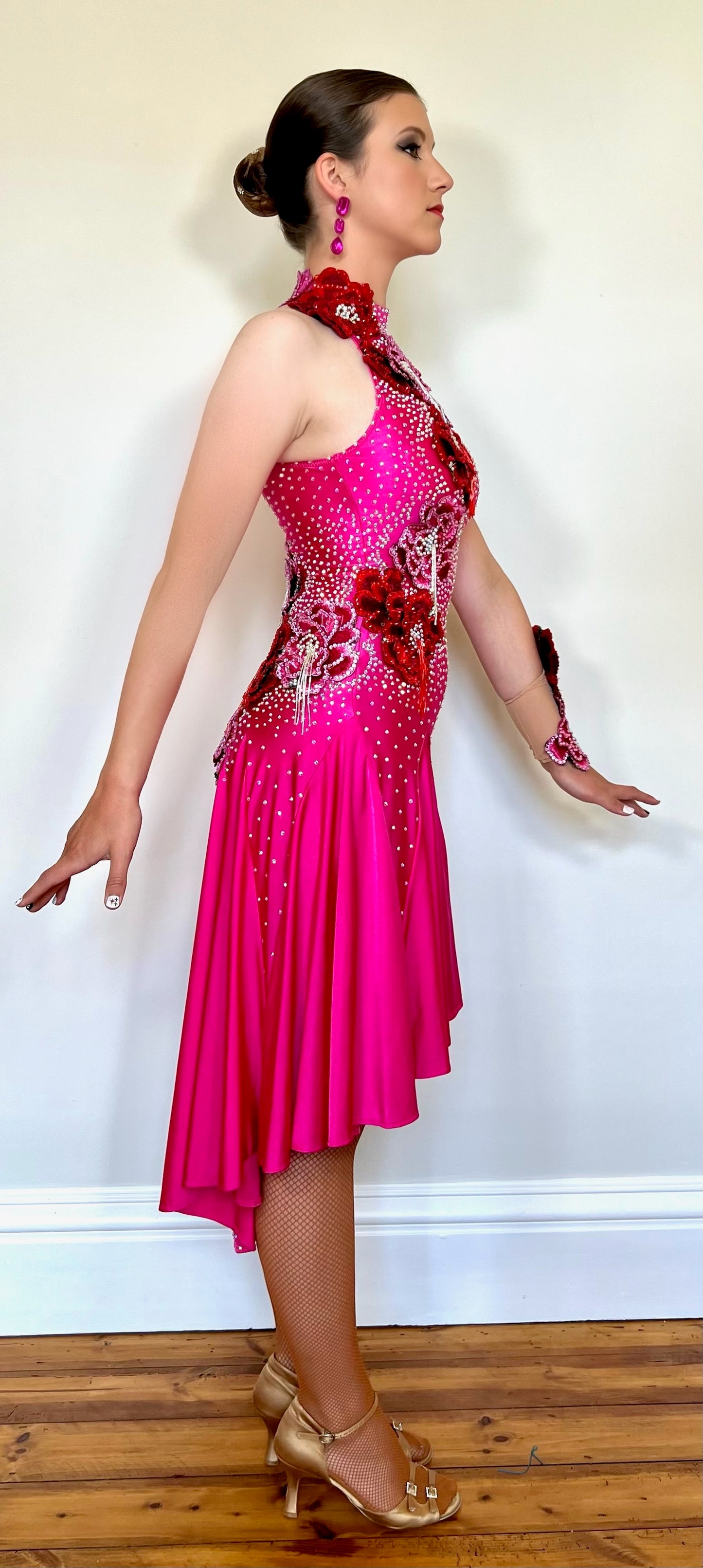 018 Magenta Halter neck style Latin dress. Shaped skirt with side split. 3D flower decorations to the front & back of bodice. Flowers to wrist cuff.