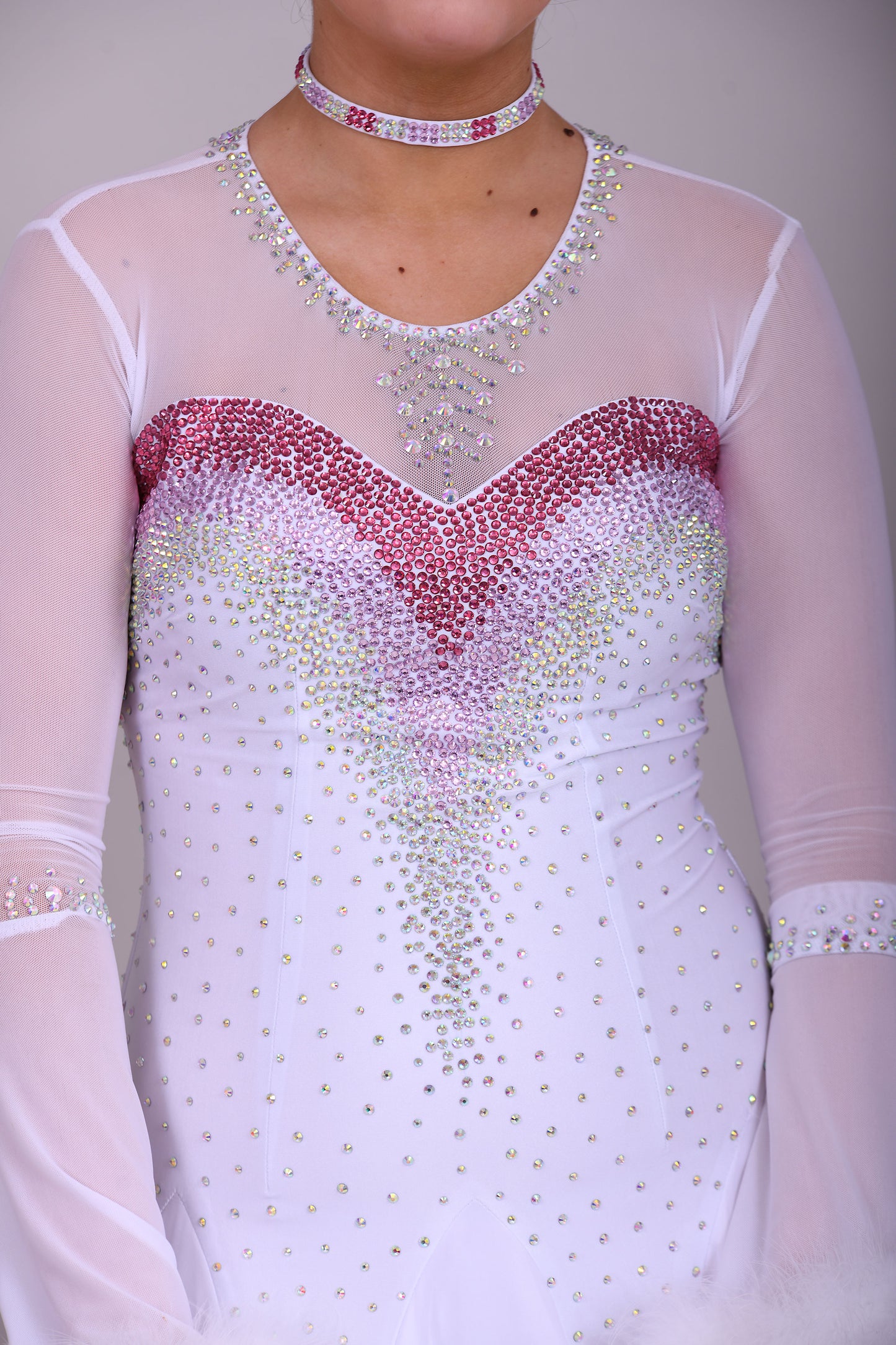 207 Pale Pink & White Ombré Ballroom Dress. Scoop neck & High mesh back. Feature stoning at the chest in rose, light rose & AB. Feather detailing to bell sleeves.