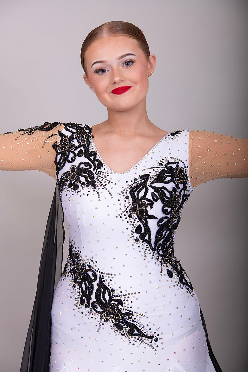 048 White Ballroom Dress with Black lace detailing to the upper chest & sides. Comes with x2 cuffs decorated with appliqué. Stoned in AB and Jet