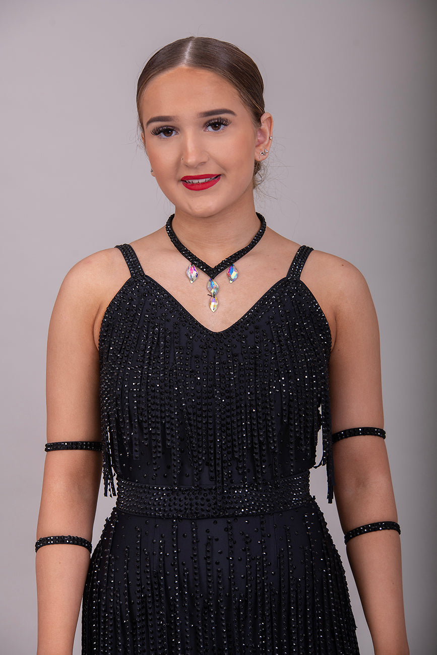 24L Black Latin/Rhythm Competition Dance Dress. Heavily stoned in Black with optional Belt. Stoned Fabric strips to the chest area and skirt. Cones with Necklace & Armbands