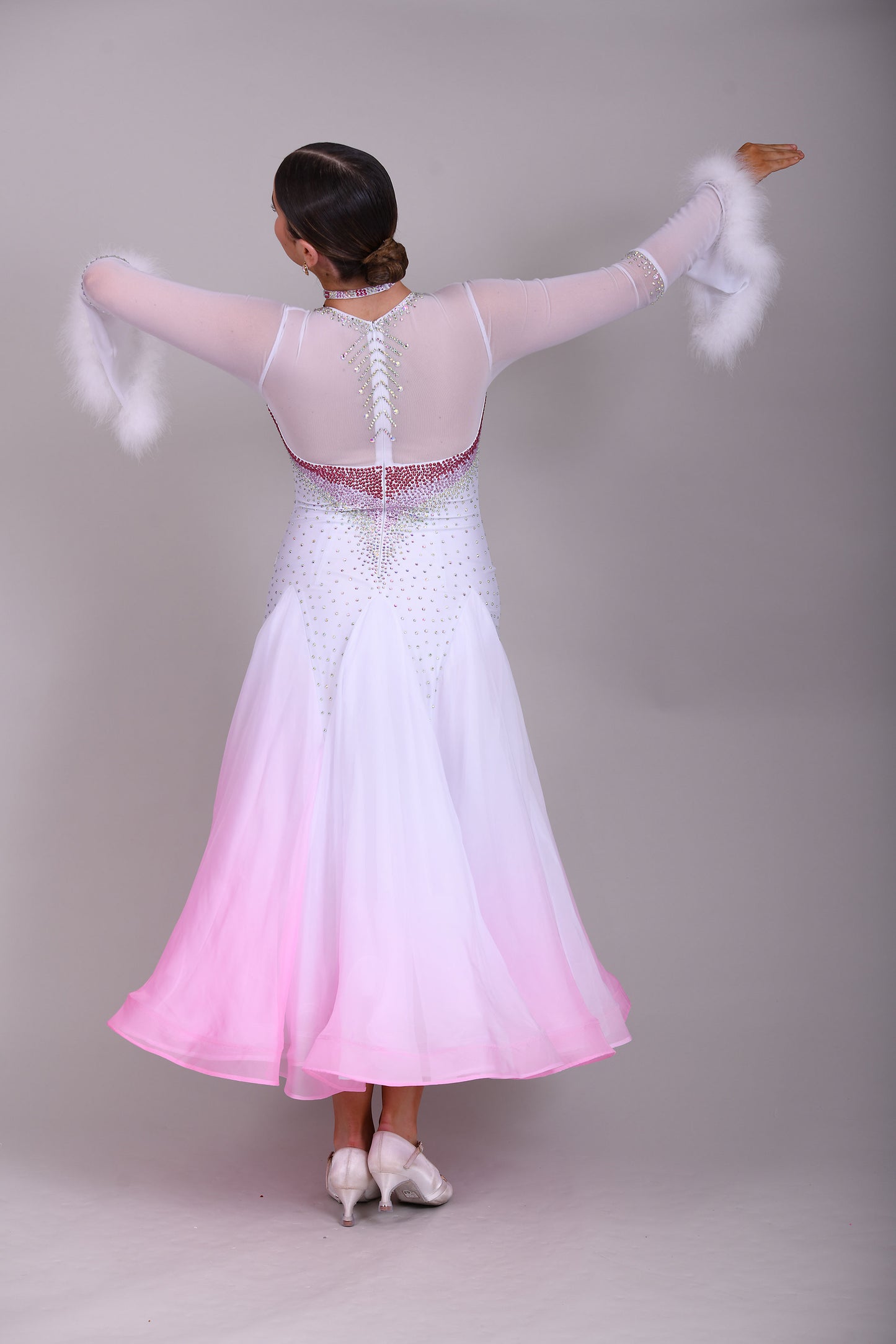 207 Pale Pink & White Ombré Ballroom Dress. Scoop neck & High mesh back. Feature stoning at the chest in rose, light rose & AB. Feather detailing to bell sleeves.