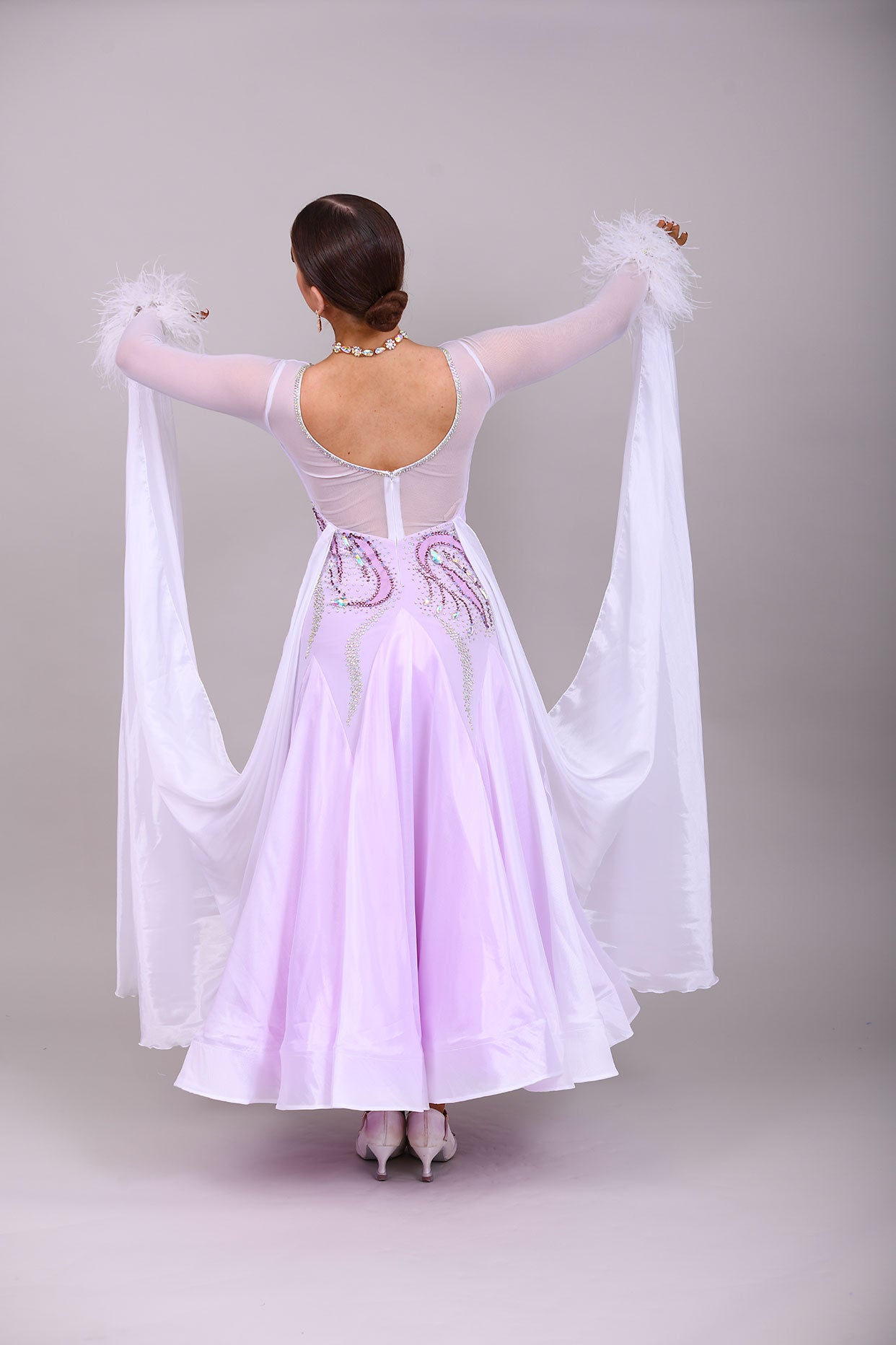 233 White Dress with lilac underlayer to the skirt. White floats. Decorated in lilac & AB stones with ostrich feather detail to the cuffs