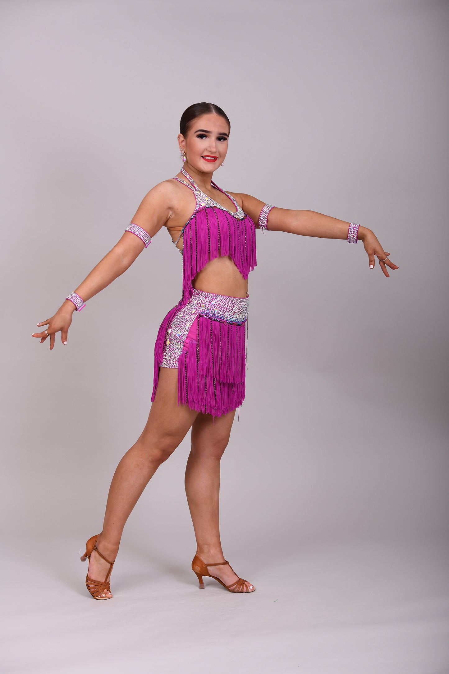 184 Fuschia Pink Latin 2 Piece. Very full fringed skirt and top. Stoned in Amethyst, AB & Aquamarine AB. Shorts attached under skirt