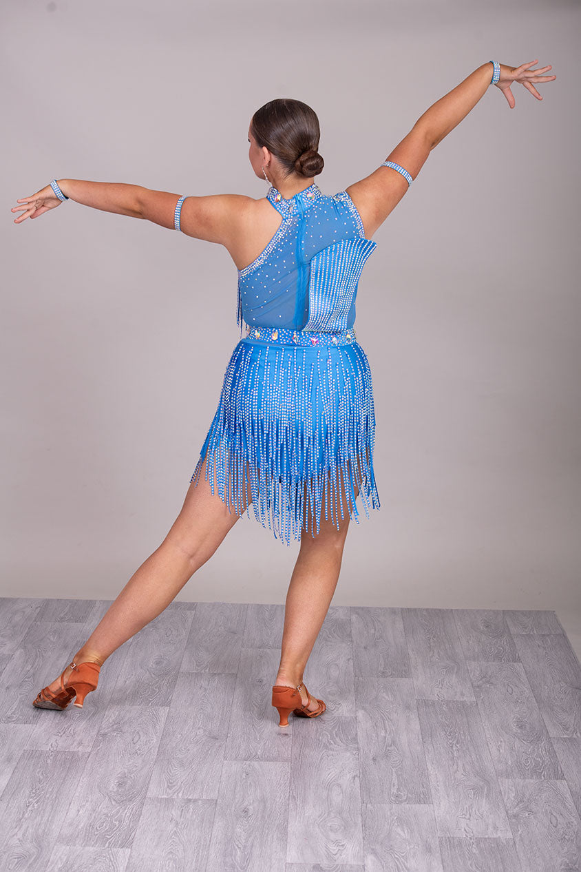 134L BUDGET (24) Blue Competition Latin Dance Dress. Stoned fabric strip detail throughout with 3D feature yo upper chest. Stoned in AB ❤️Showroom Appointments Available❤️