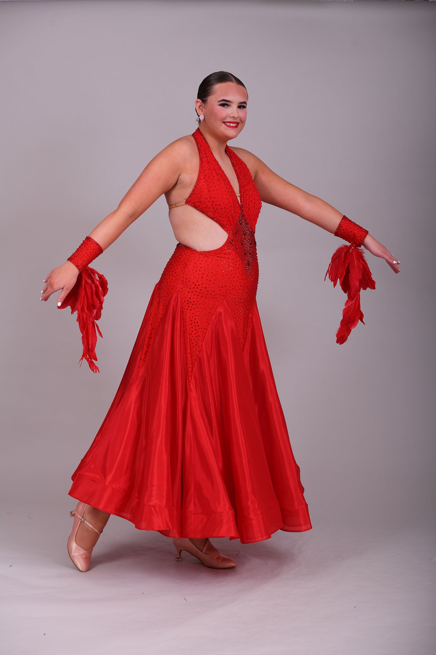 219 Red Sleeveless/Backless Ballroom/Smooth halter neck Dress. Feature panelling to the waist. Long Glove let’s with feather detailing. Flesh strapping to the chest and back.
