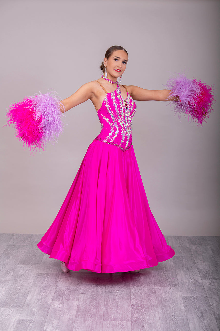 005 Cerise Pink Competition Ballroom Dance Dress. Heavily stoned in AB and Fuchsia & lilac. Comes with ostrich cuffs in Lilac & Cerise. Beautiful back detail.