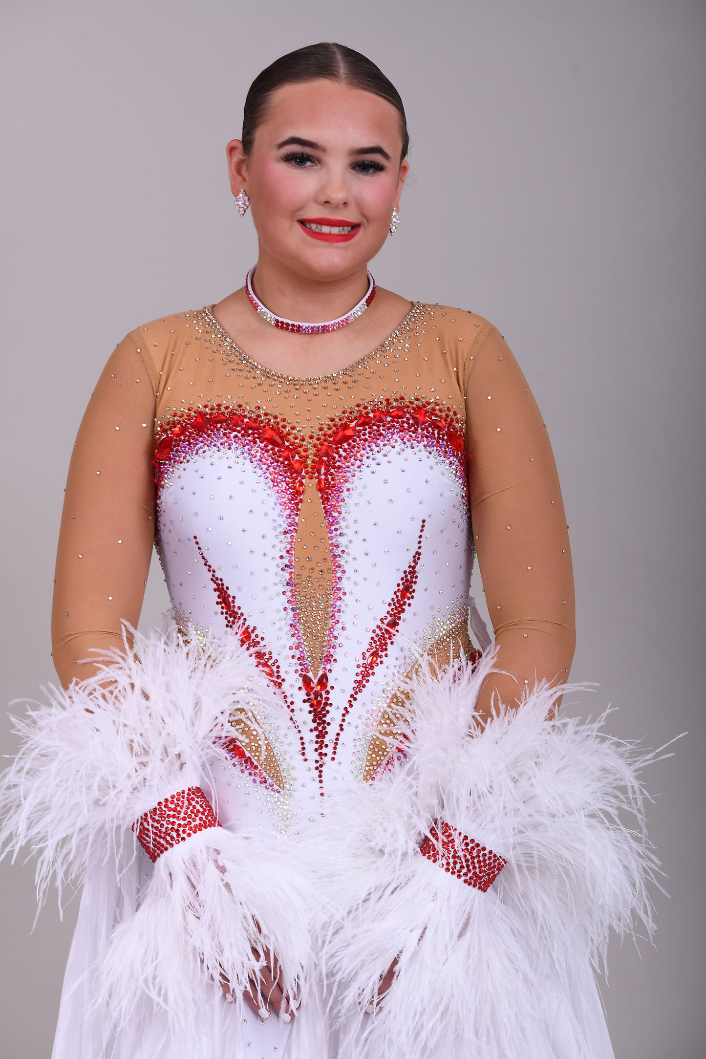 011 White & Mid Tan Competition Ballroom Dance Dress. Pleated pearl Chiffon skirt with beautiful keyhole Back. Stoned accents in Siam, Siam AB, AB & Golden Shadow. Comes with detachable pleated floats and feather cuffs.