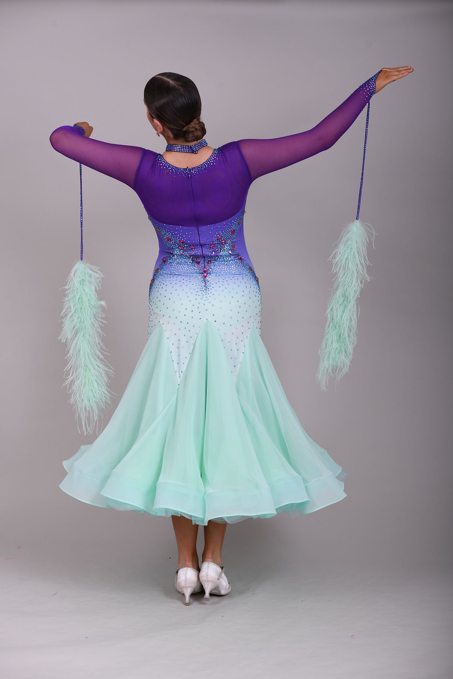 167 Ombré purple to mint green competition Ballroom dance dress. Stoned in mint green, mint green ab, purple & vitrail. Ostrich feather floats attached to stoned strips. High back to give the option of wearing own bra.
