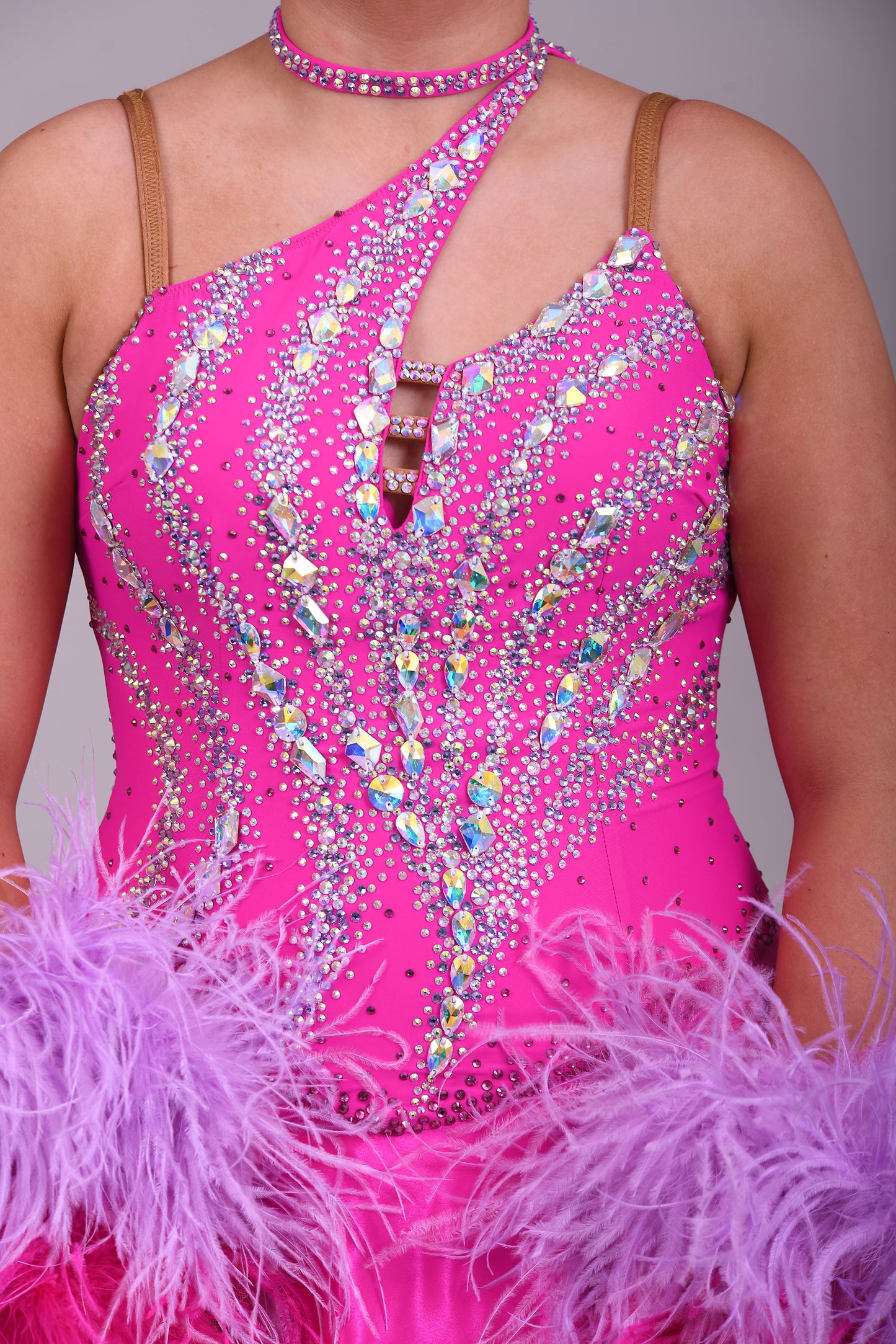 005 Cerise Pink Competition Ballroom Dance Dress. Heavily stoned in AB and Fuchsia & lilac. Comes with ostrich cuffs in Lilac & Cerise. Beautiful back detail.