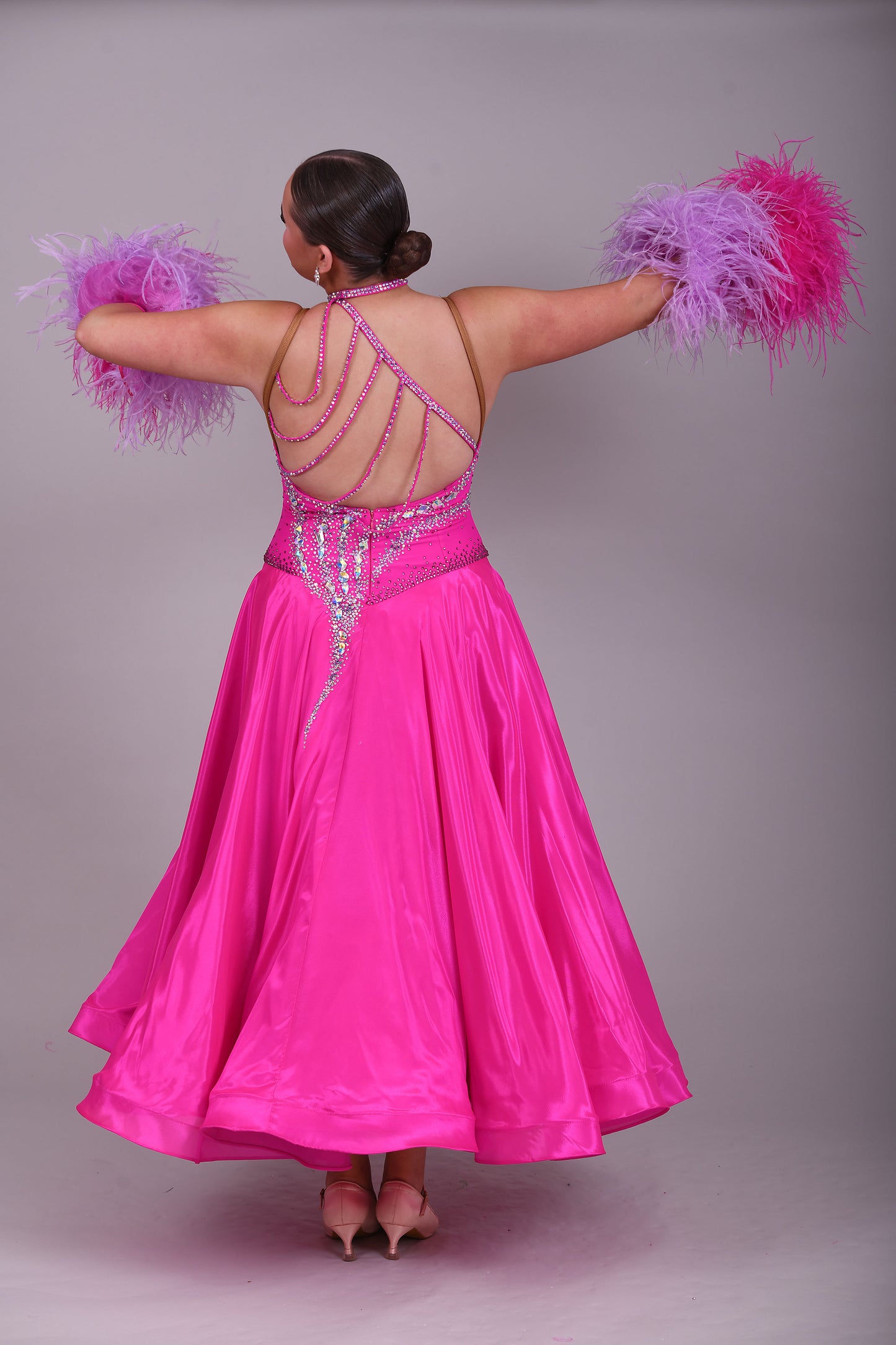 005 Cerise Pink Competition Ballroom Dance Dress. Heavily stoned in AB and Fuchsia & lilac. Comes with ostrich cuffs in Lilac & Cerise. Beautiful back detail.