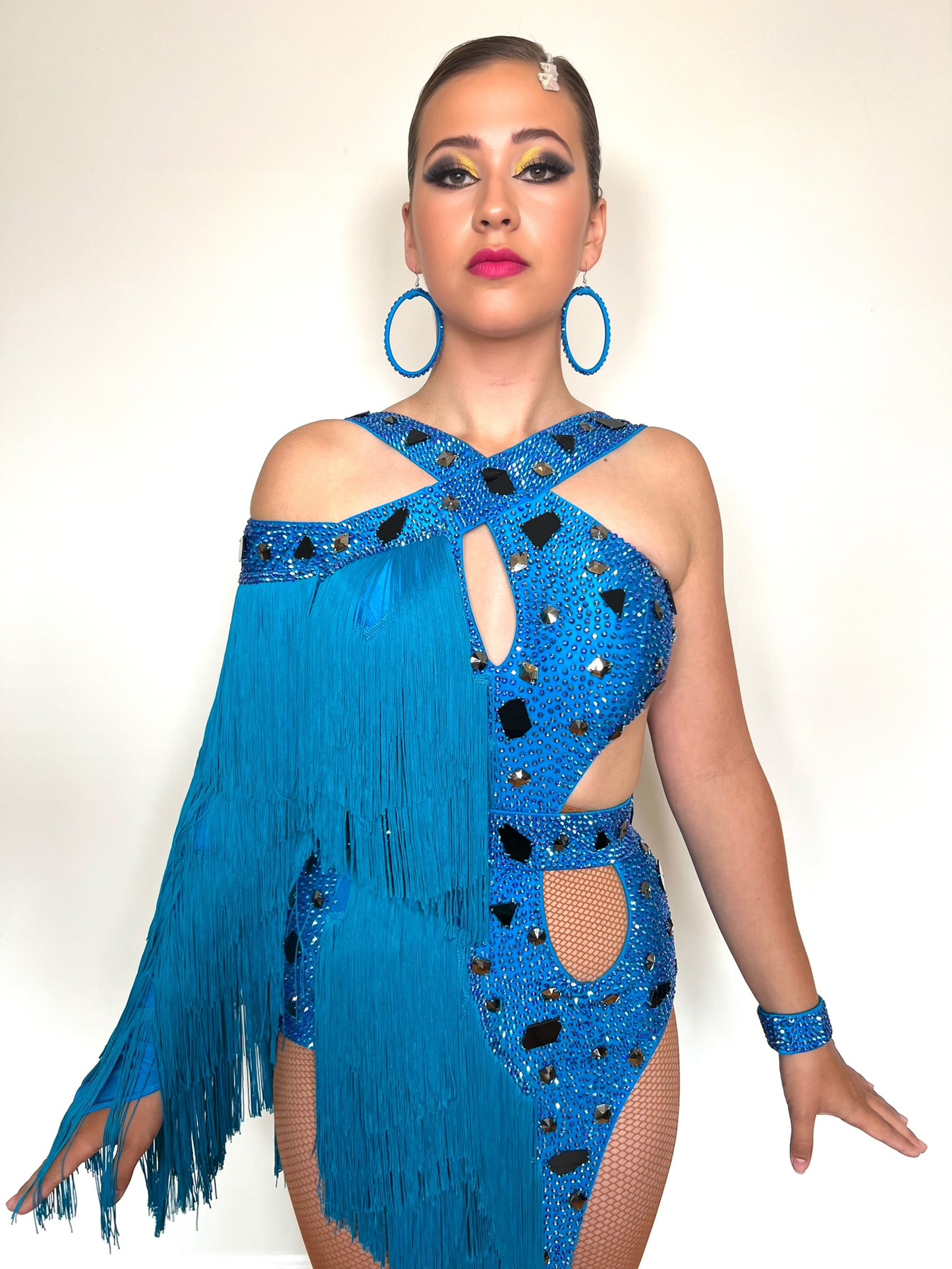 310 Statement Turquoise Latin Dress. Fringed one arm dress with strapping details decorated with Turquoise stones.