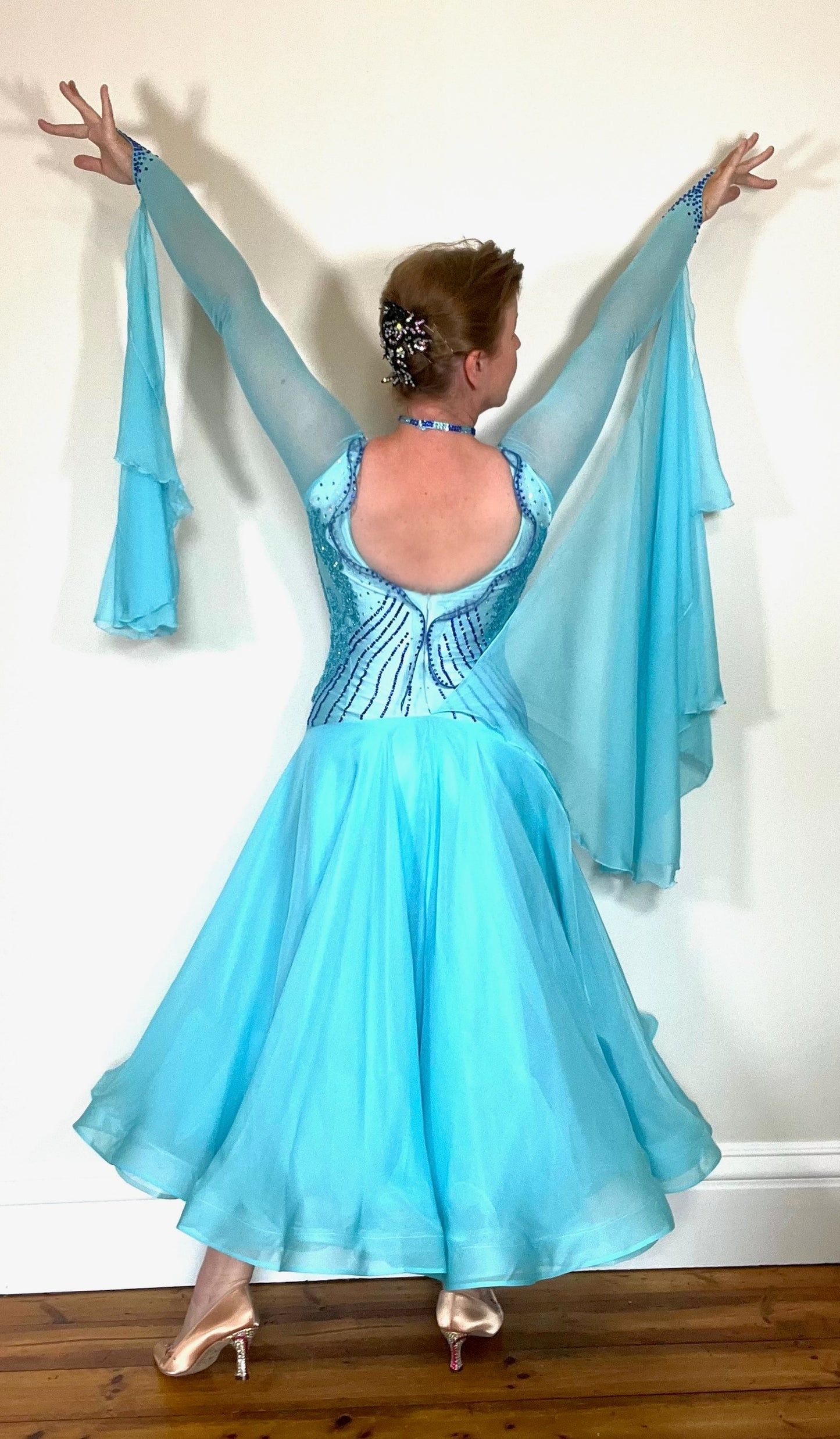 334 Paradise Blue Ballroom Dress. Decorated with Sapphire & Light Sapphire stones with matching appliqués to the side areas. Detailing to the chest and back.