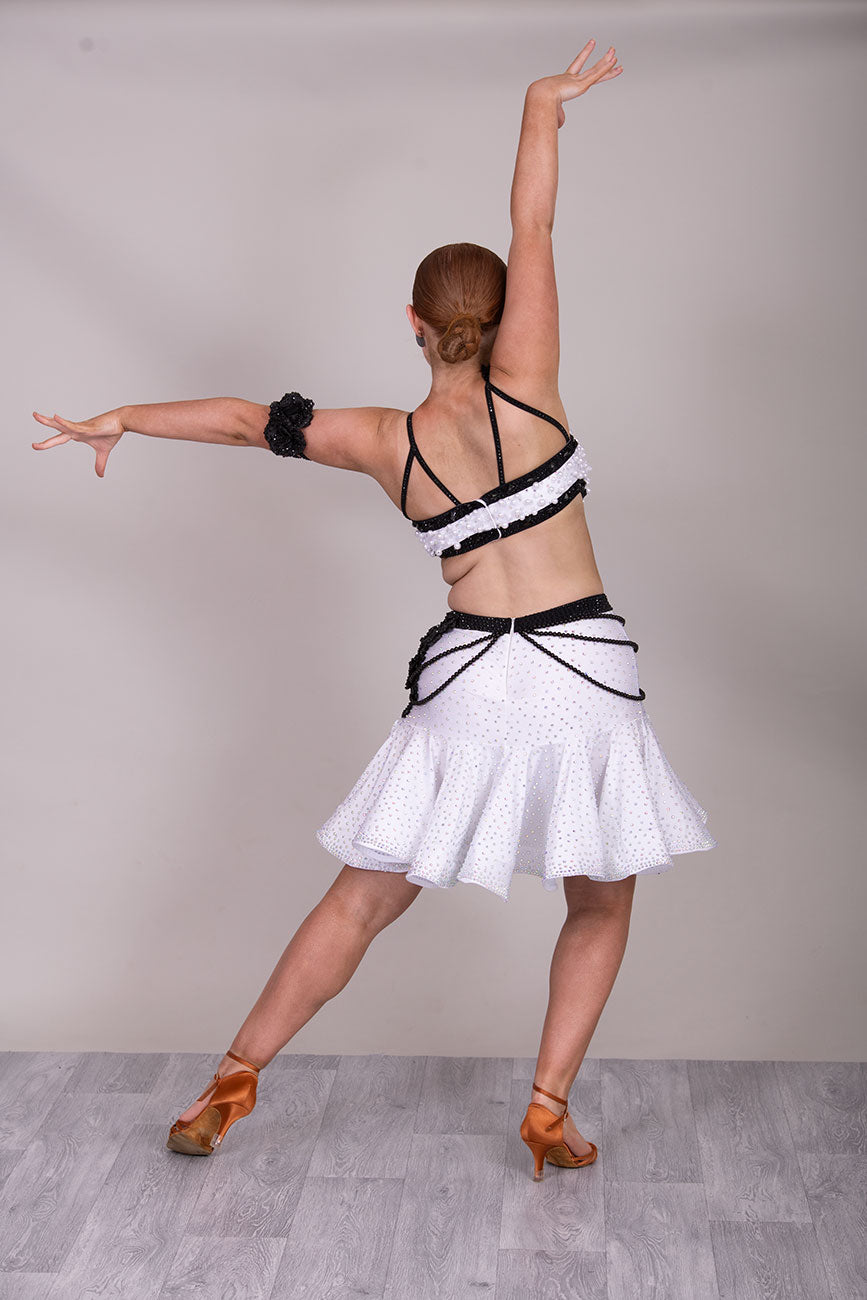 (BUDGET)10 Striking White & Black Competition Latin Dance Dress. Heavily decorated with white pearls & Black bedding all over. Stoned black motif & flower detailing to the hip.