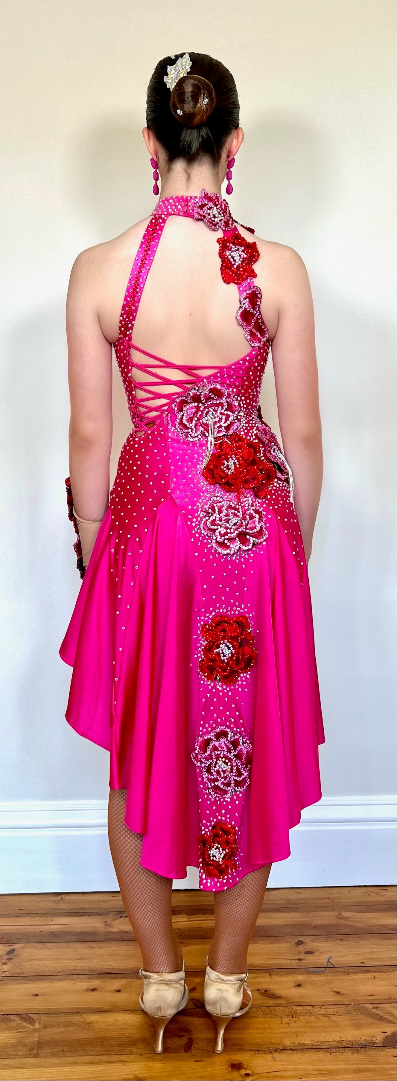 018 Magenta Halter neck style Latin dress. Shaped skirt with side split. 3D flower decorations to the front & back of bodice. Flowers to wrist cuff.