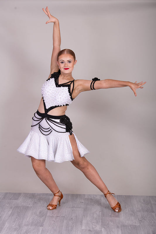(BUDGET)10 Striking White & Black Competition Latin Dance Dress. Heavily decorated with white pearls & Black bedding all over. Stoned black motif & flower detailing to the hip.