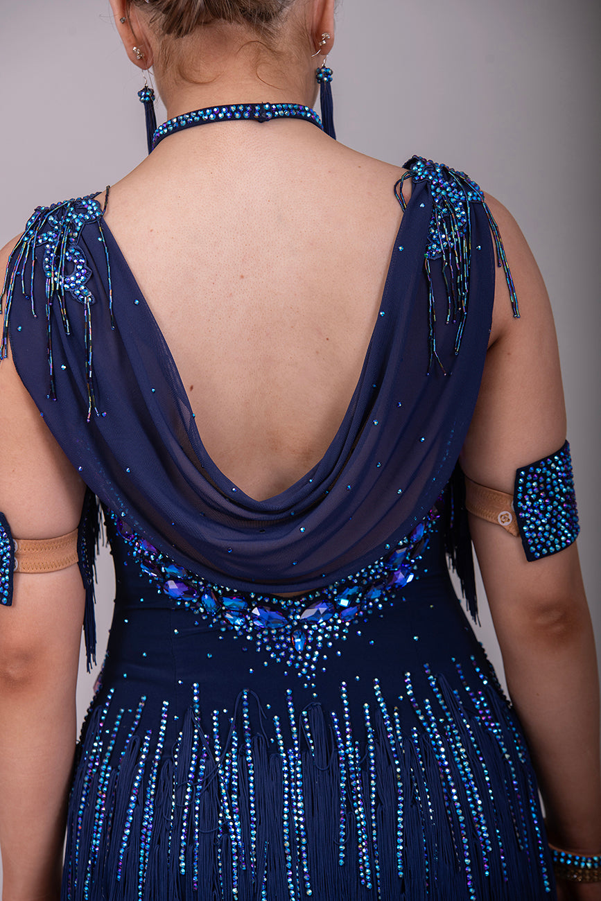 14L Navy Blue Competition Latin/Rhythm Dress. Stoned Fabric Tassels for the Skirt & Upper Chest. Heavily Stoned in Blue AB & Blue. Strappy detailing to the Hips & Drape to the back