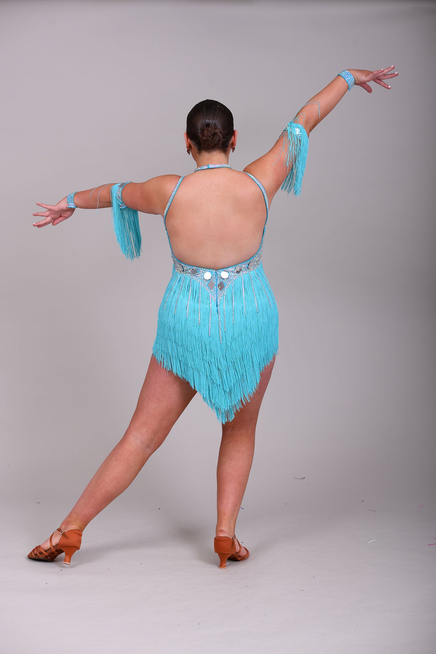 001 Turquoise Blue Competition Latin Dance Dress. Very full Fringes. 3D flower detail to the left shoulder. Cones with fringed armbands and bracelets. Decorated with silver mirrors & AB stones.