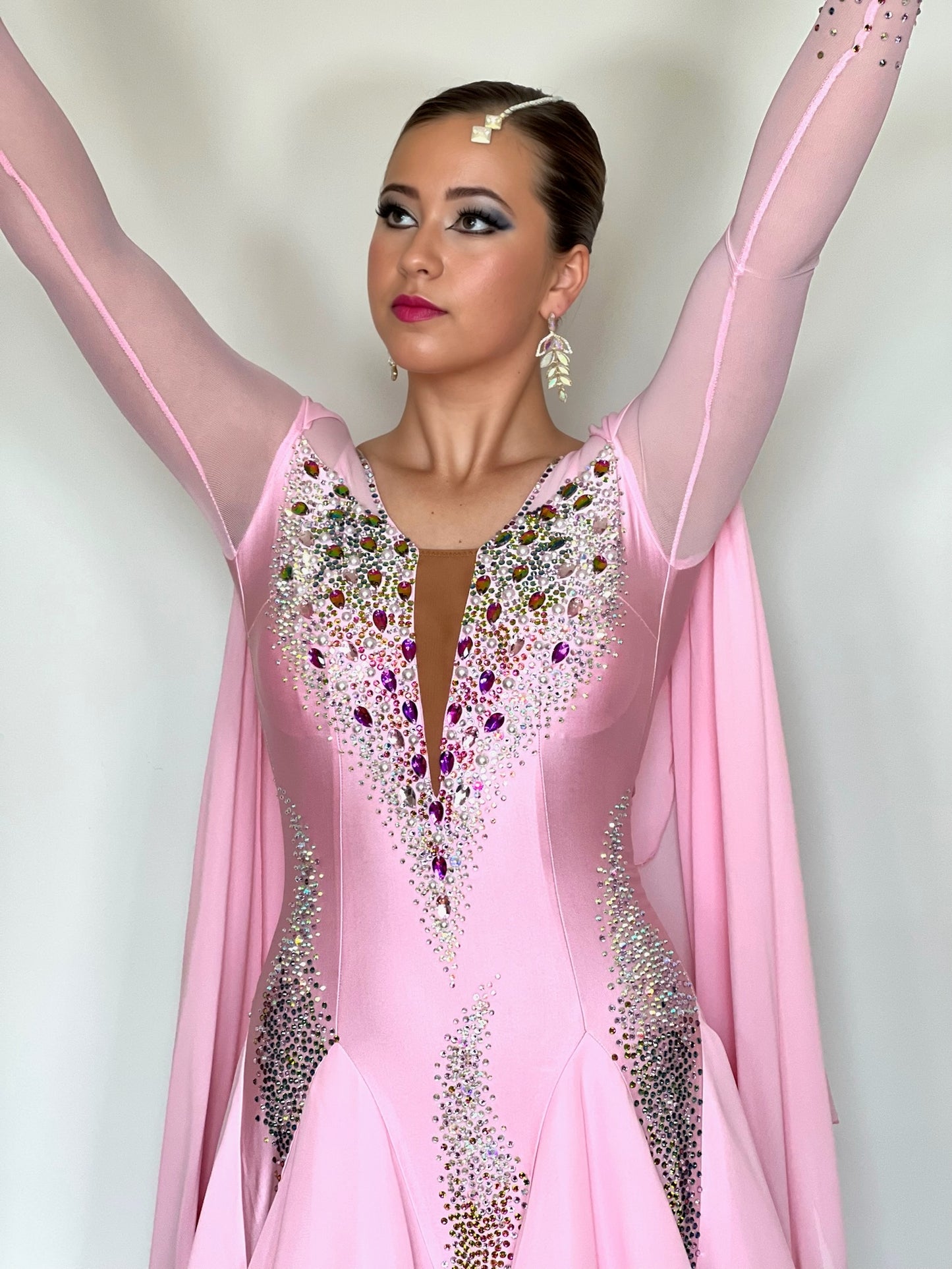 131 Pink Ballroom Dress with shoulder floats. Tan panel to the chest area giving a plunging neckline effect. Decorated in AB & Fuchsia stones