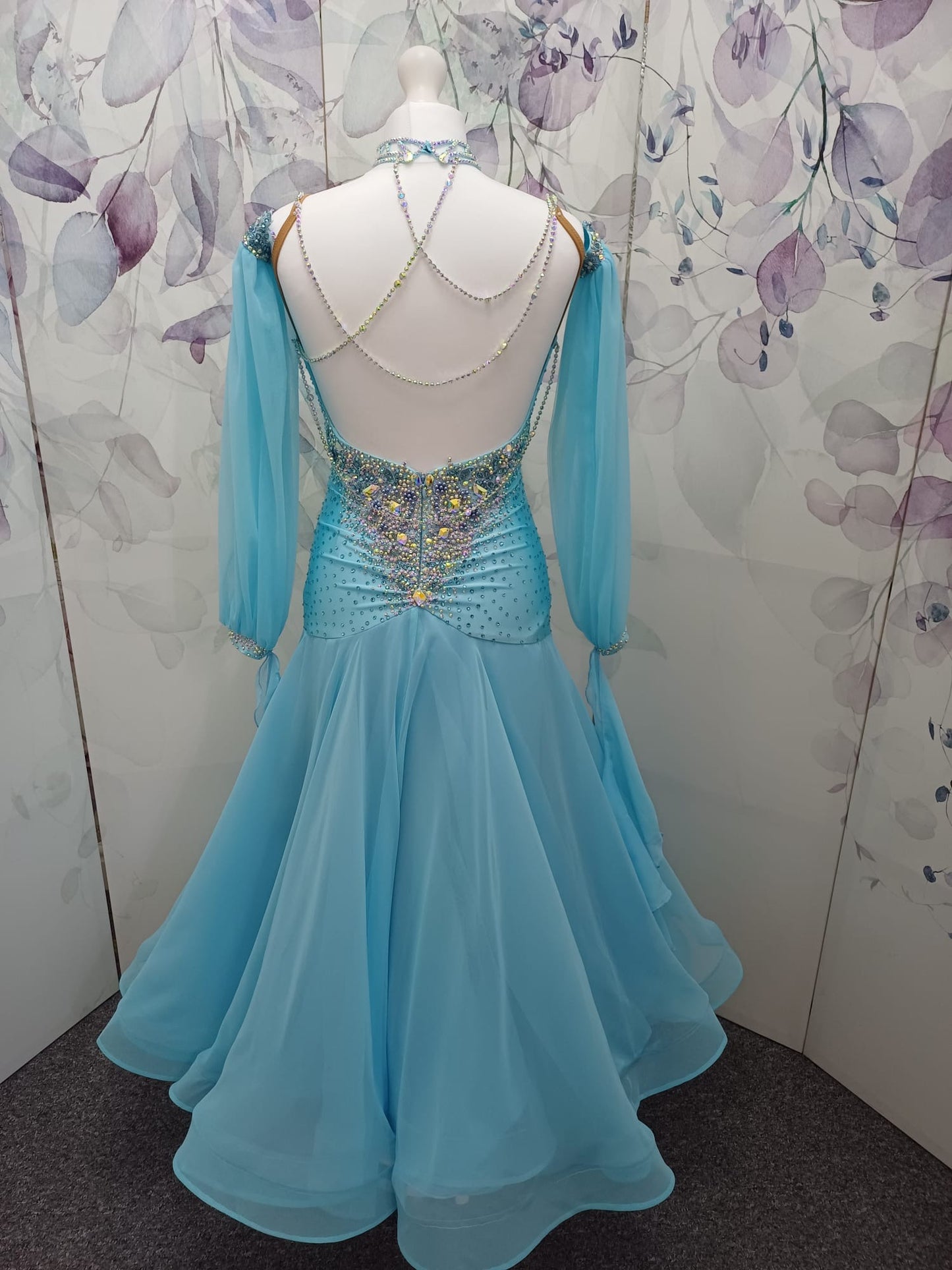 72B TWD Petite Beautiful Blue Competition Ballroom/Sequence Dance Dress. Heavy appliqué stoning to upper chest in Light Sapphire & AB. Separate puff arms with detachable wrist floats. ❤️Showroom Appointments Available❤️