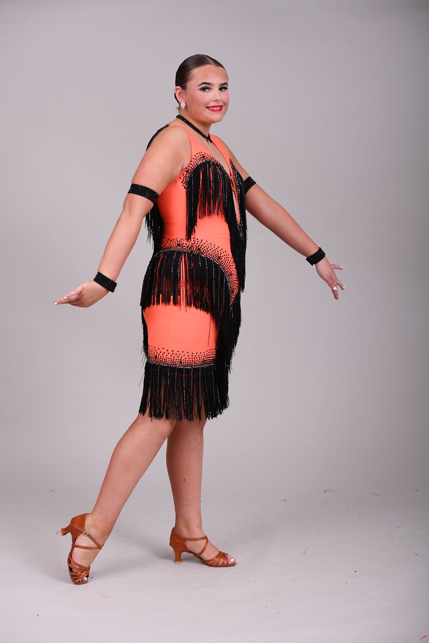 133 Flo Orange Latin dress with black fringe detailing. Plunge neckline. Material droppers stoned in hematite in amongst the fringing. Jet stones.