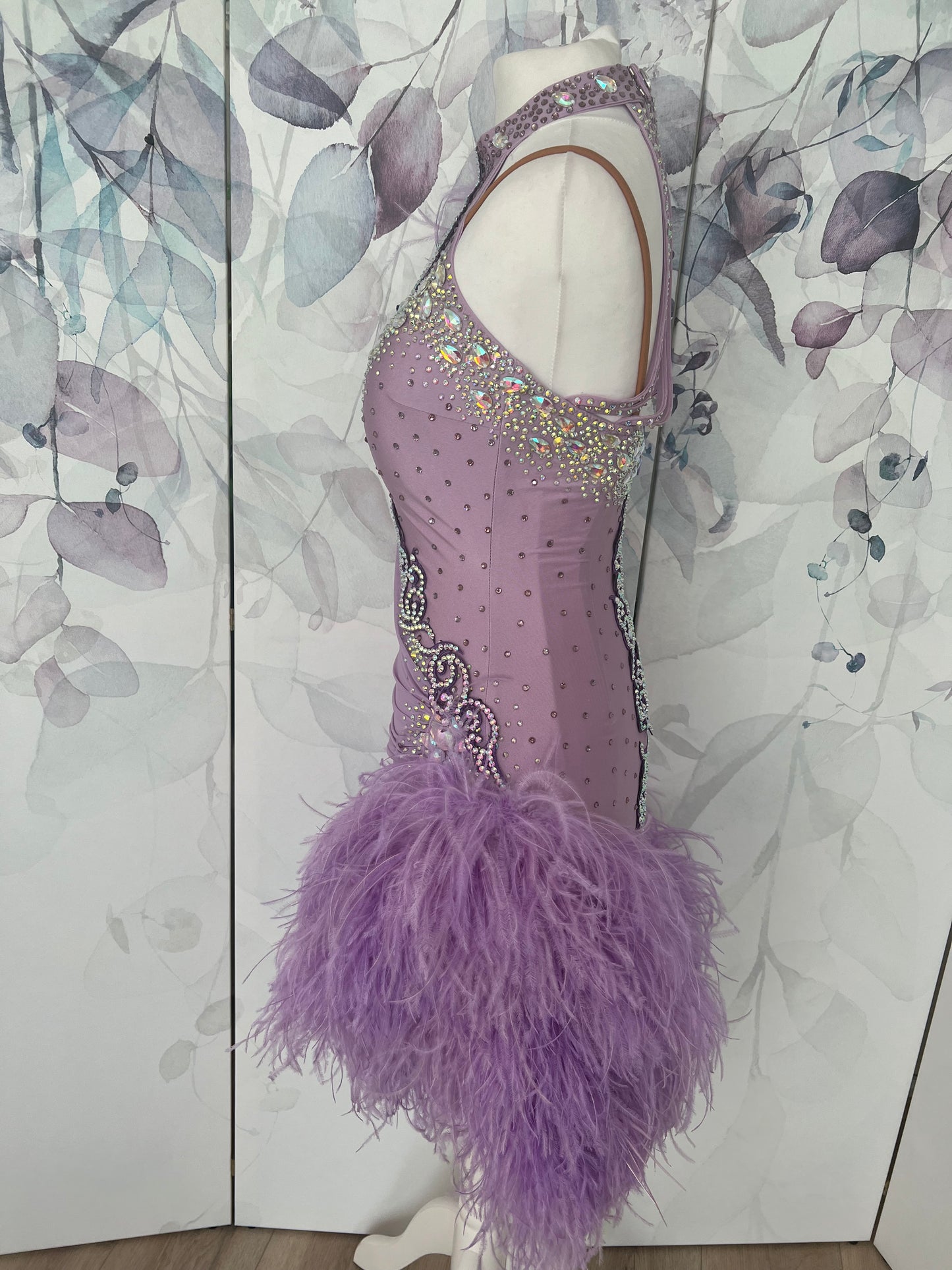 344 Lilac Latin Dress with keyhole halter neck detail. Strapping design on back. Lilac ostrich feather boa skirt. Decorated with purple motif. Stoned in green & AB