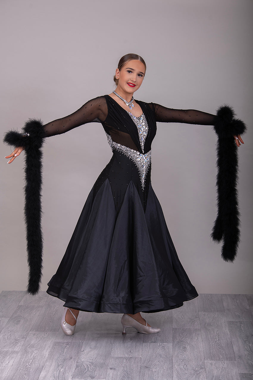 324 Black Ballroom Dress with feather floats to the wrist. Rouched detail to the chest area. Heavily decorated stoning to the front & back in AB. High back.