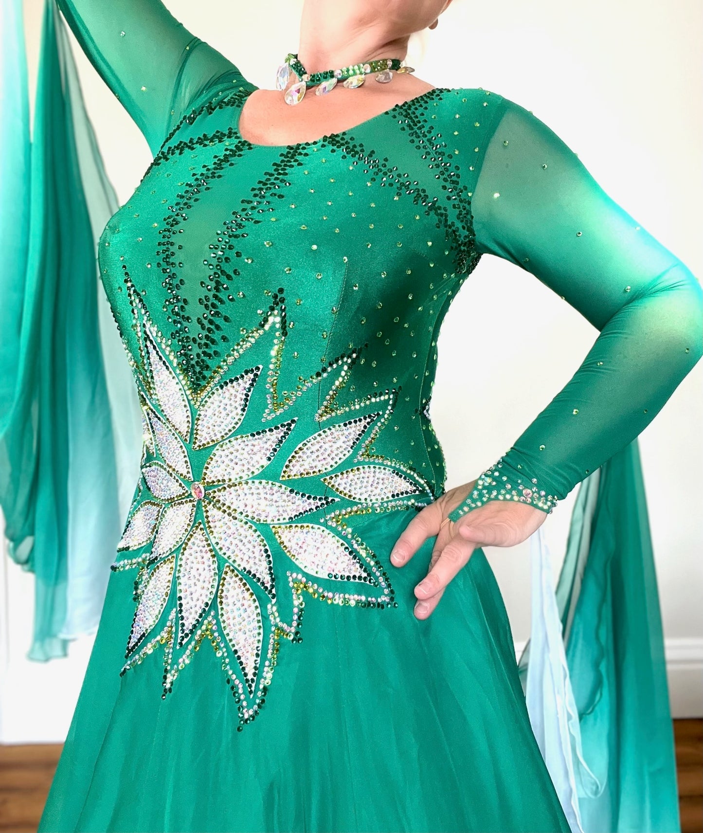 338 Emerald, Jade & White Ombré Ballroom Dress. Stunning decoration the the waist in White decorated with gold & AB stones. Dress decorated with light & dark green stones. Ombré floats to the back & sleeves.