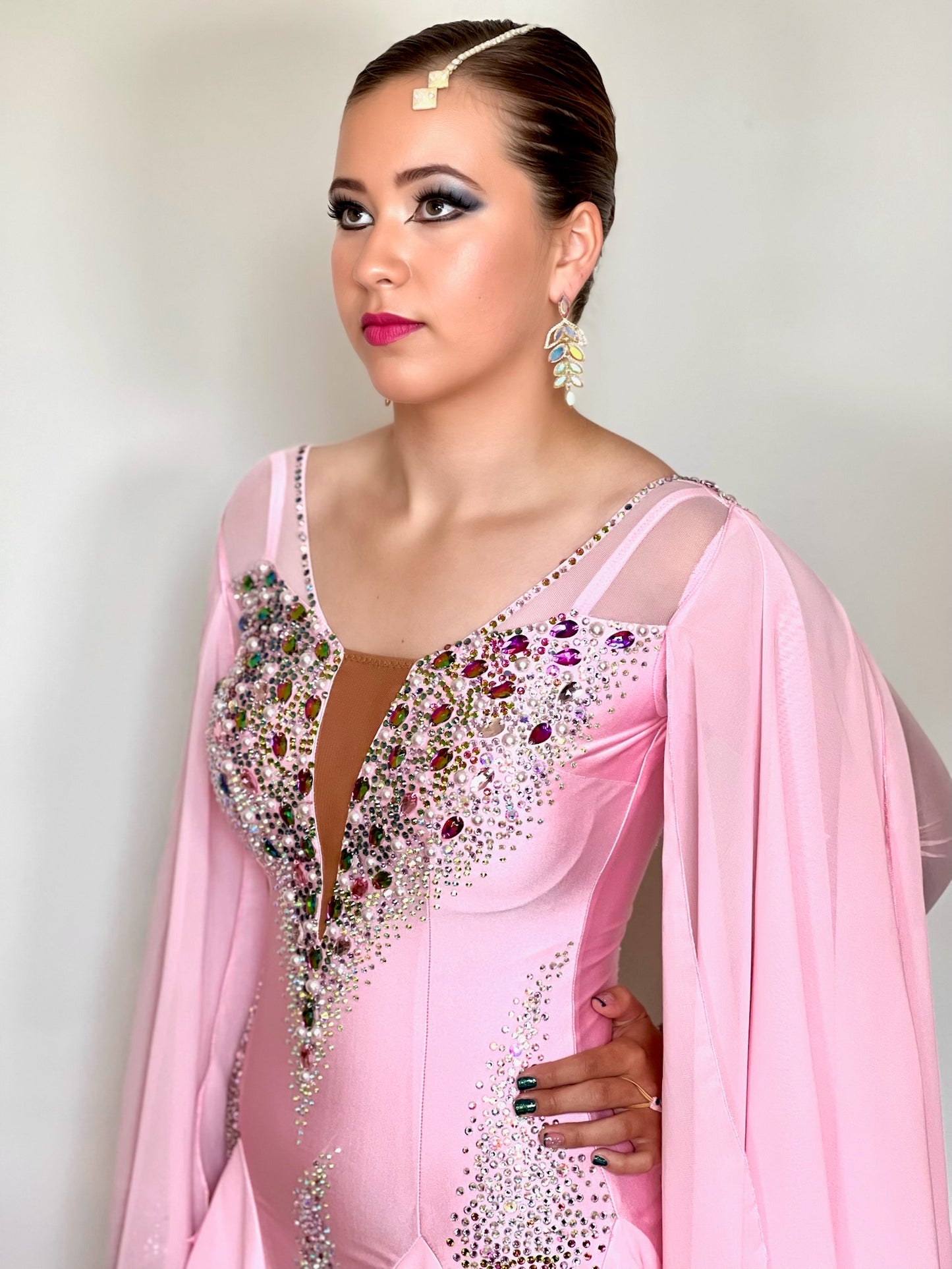 131 Pink Ballroom Dress with shoulder floats. Tan panel to the chest area giving a plunging neckline effect. Decorated in AB & Fuchsia stones