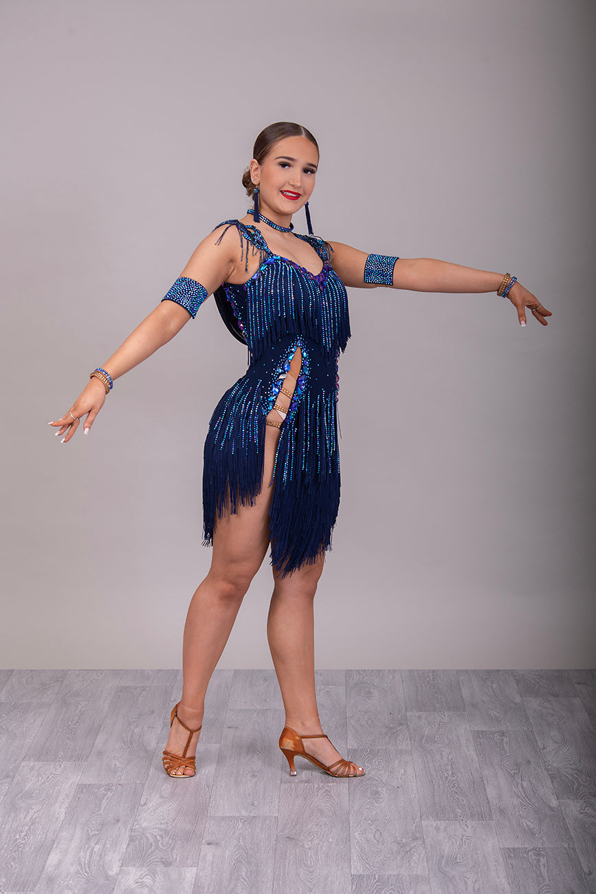 14L Navy Blue Competition Latin/Rhythm Dress. Stoned Fabric Tassels for the Skirt & Upper Chest. Heavily Stoned in Blue AB & Blue. Strappy detailing to the Hips & Drape to the back