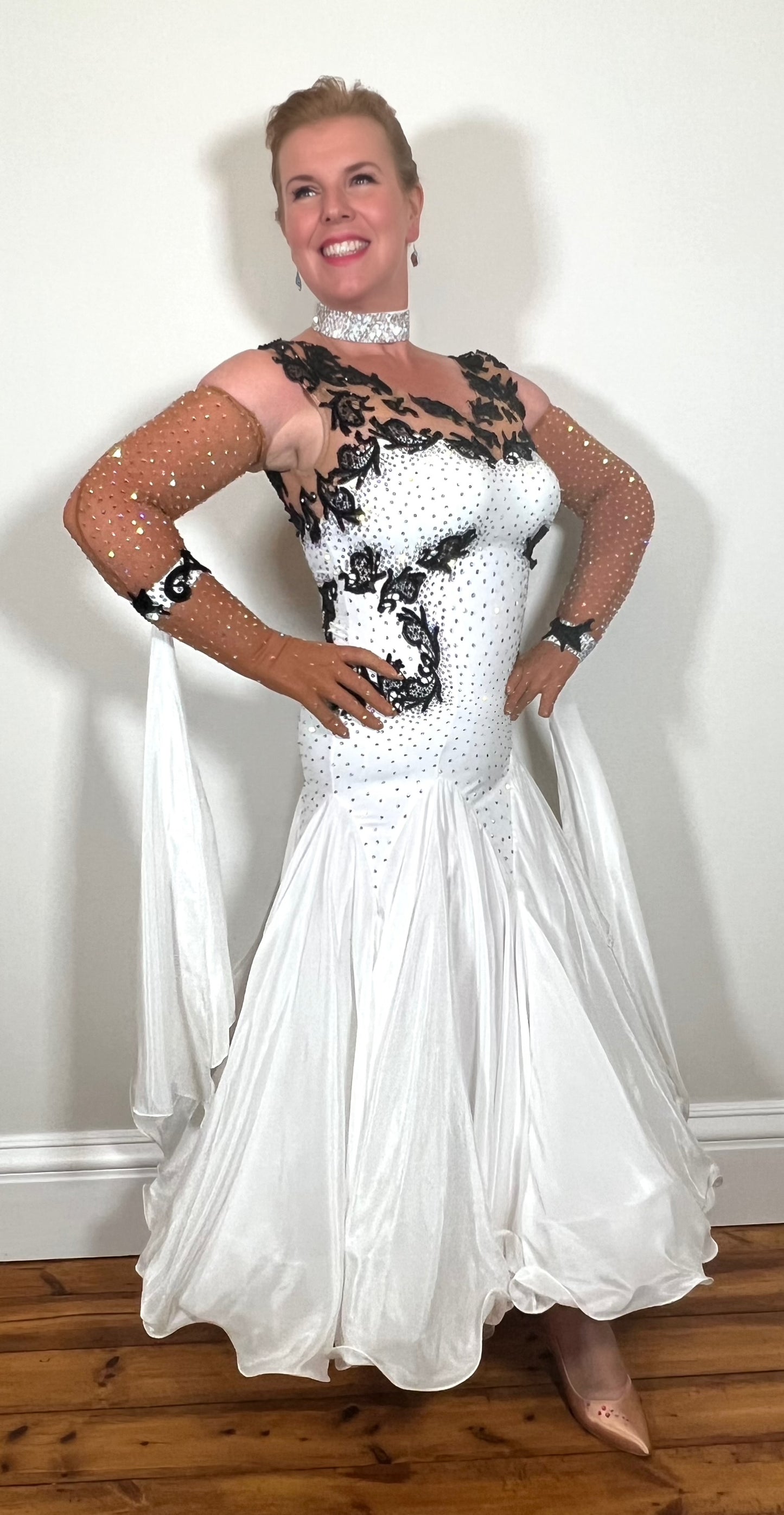 048 White Ballroom Dress with Black lace detailing to the upper chest & sides. Comes with x2 cuffs decorated with appliqué. Stoned in AB and Jet