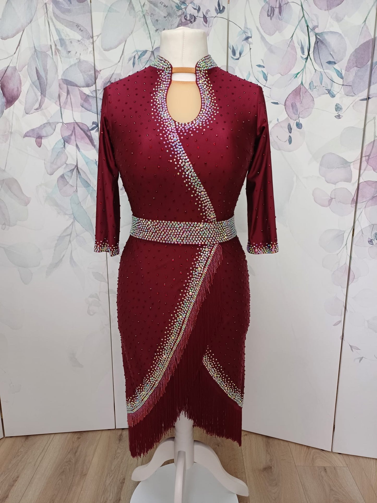 012 Wine Red Latin Dance Dress. Wine bead fringe & tassel fringe feature to the skirt. Stoned in AB & Wine red with mid tan mesh keyhole panel to the front. Optional Belt.