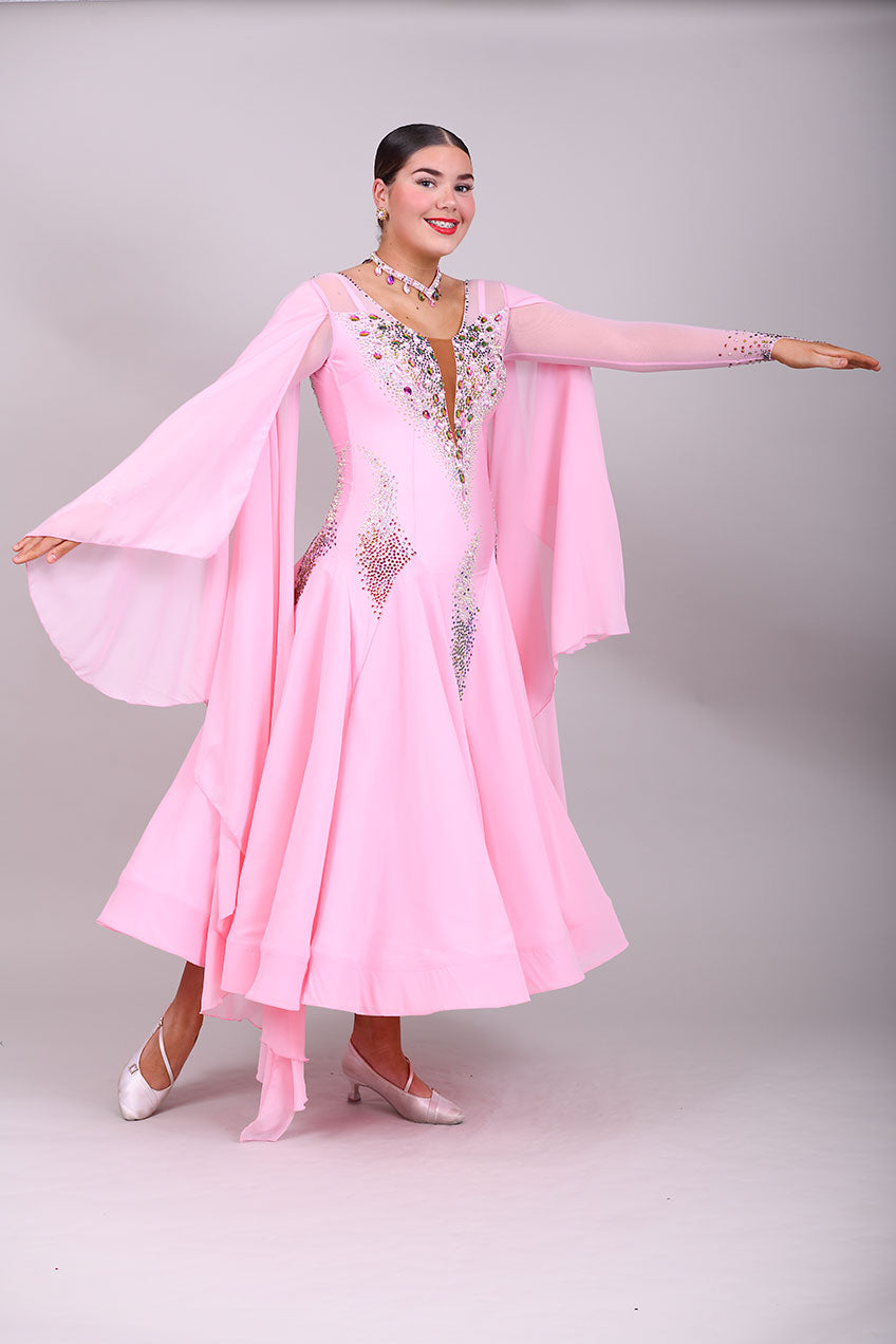131 Pink Ballroom Dress with shoulder floats. Tan panel to the chest area giving a plunging neckline effect. Decorated in AB & Fuchsia stones