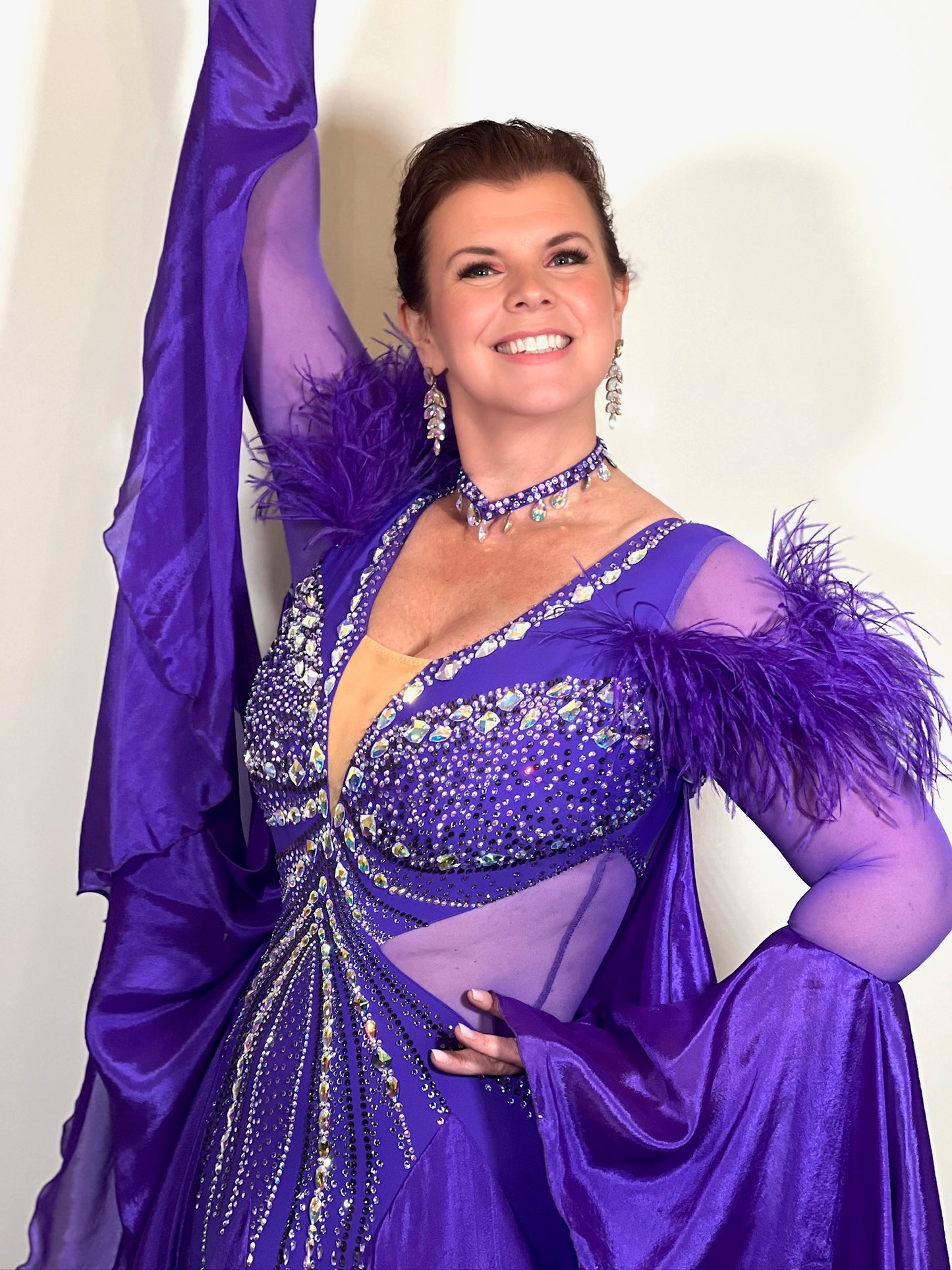 287 Stunning Purple Ballroom Dance Dress. Ostrich feather detail to the upper arm with floaty sleeves from the elbow(finger loop can be added). High back for wearing own bra. Stoned in AB, light Amethyst & Amethyst.