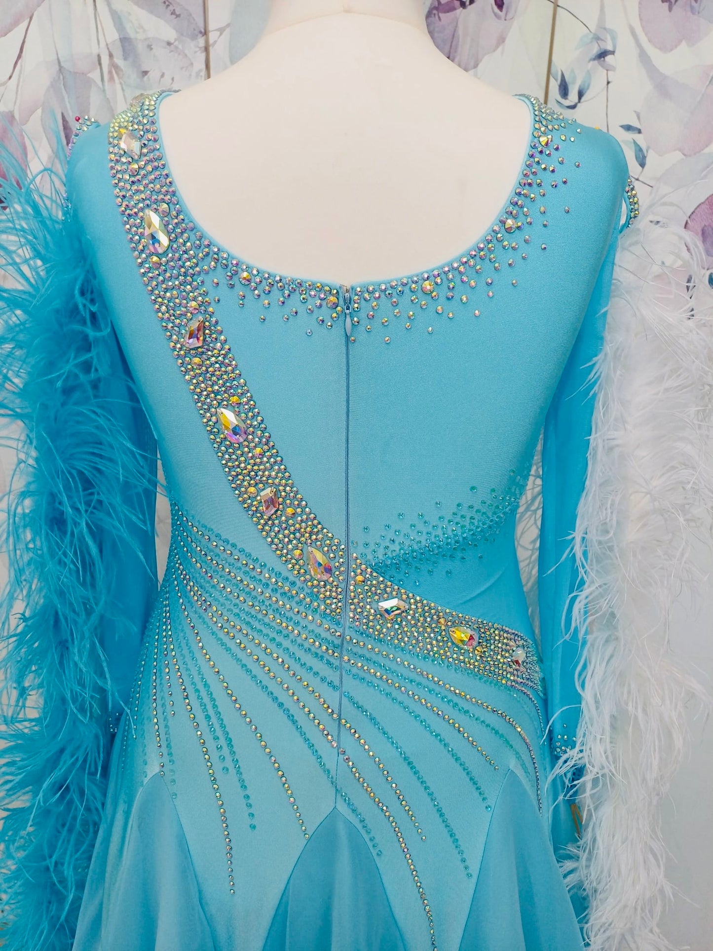 277 Beautiful Ice Blue Competition Ballroom Dance Dress. Stones in AB. Comes with Ostrich feather boa floats. These can be blue & white or a mix of the 2 colours. High back to all for wearing own bra.