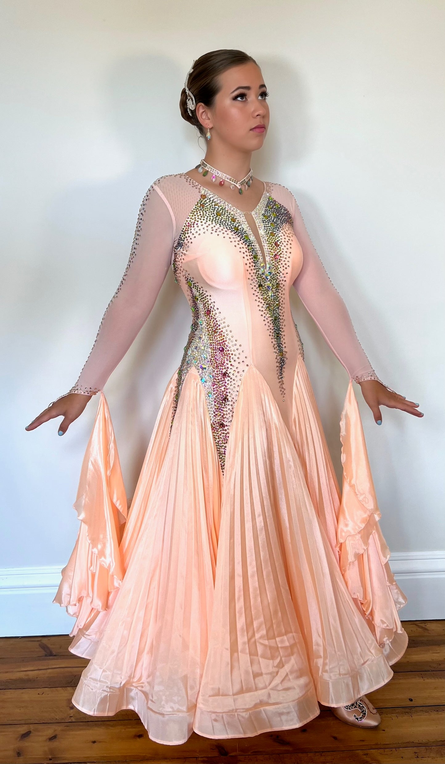 229 Peach Pleated Skirt Ballroom Dress. Rainbow & peach stoning. High back & mesh sleeves with floats attached.