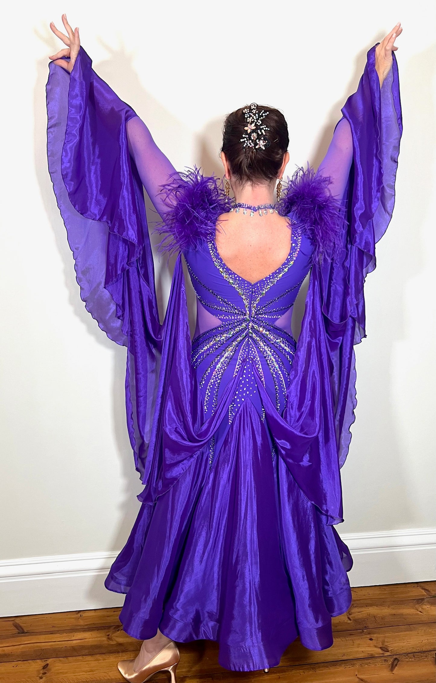 287 Stunning Purple Ballroom Dance Dress. Ostrich feather detail to the upper arm with floaty sleeves from the elbow(finger loop can be added). High back for wearing own bra. Stoned in AB, light Amethyst & Amethyst.