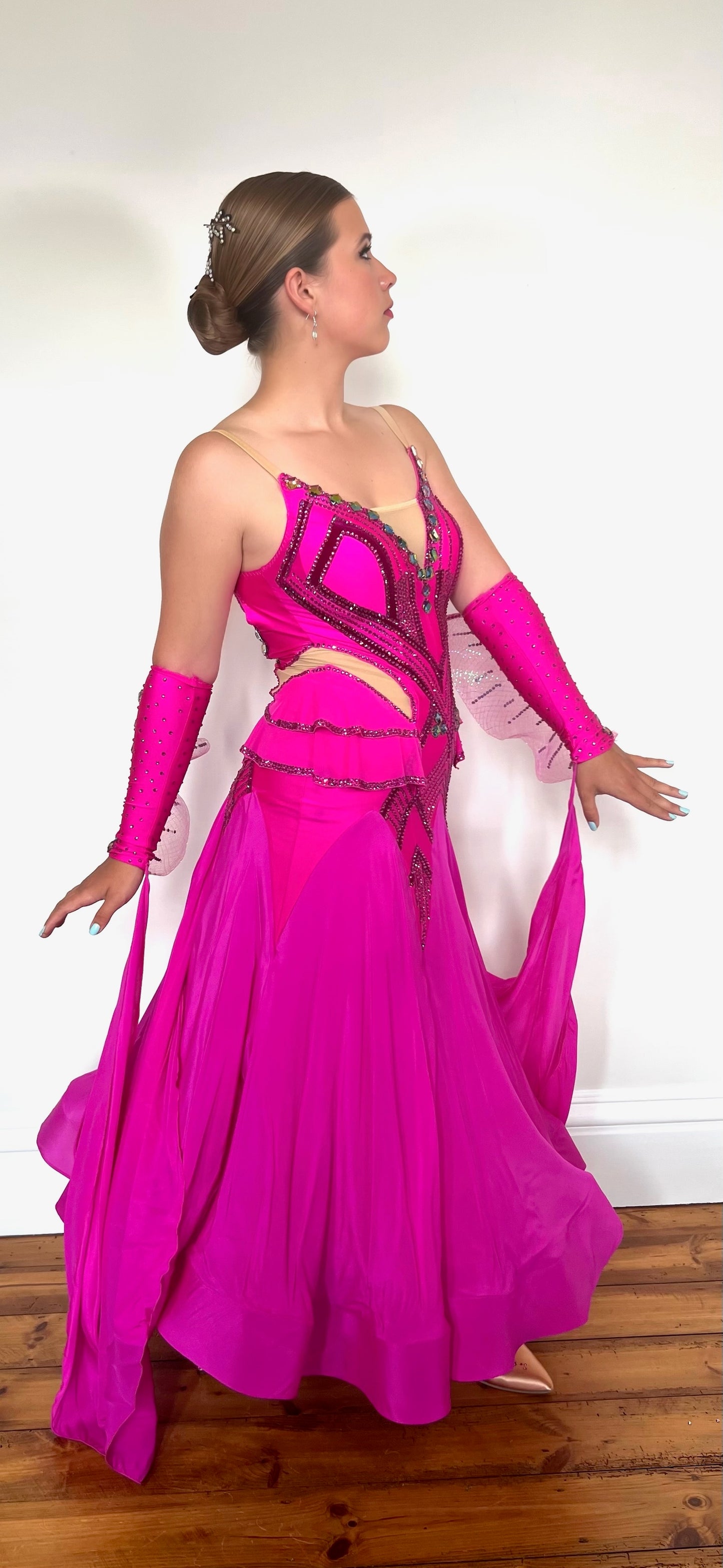211 Magenta Pink Ballroom Dress. Flesh detailed panelling throughout bodice. Gloveless with organza detail & floats. Stoned in magenta