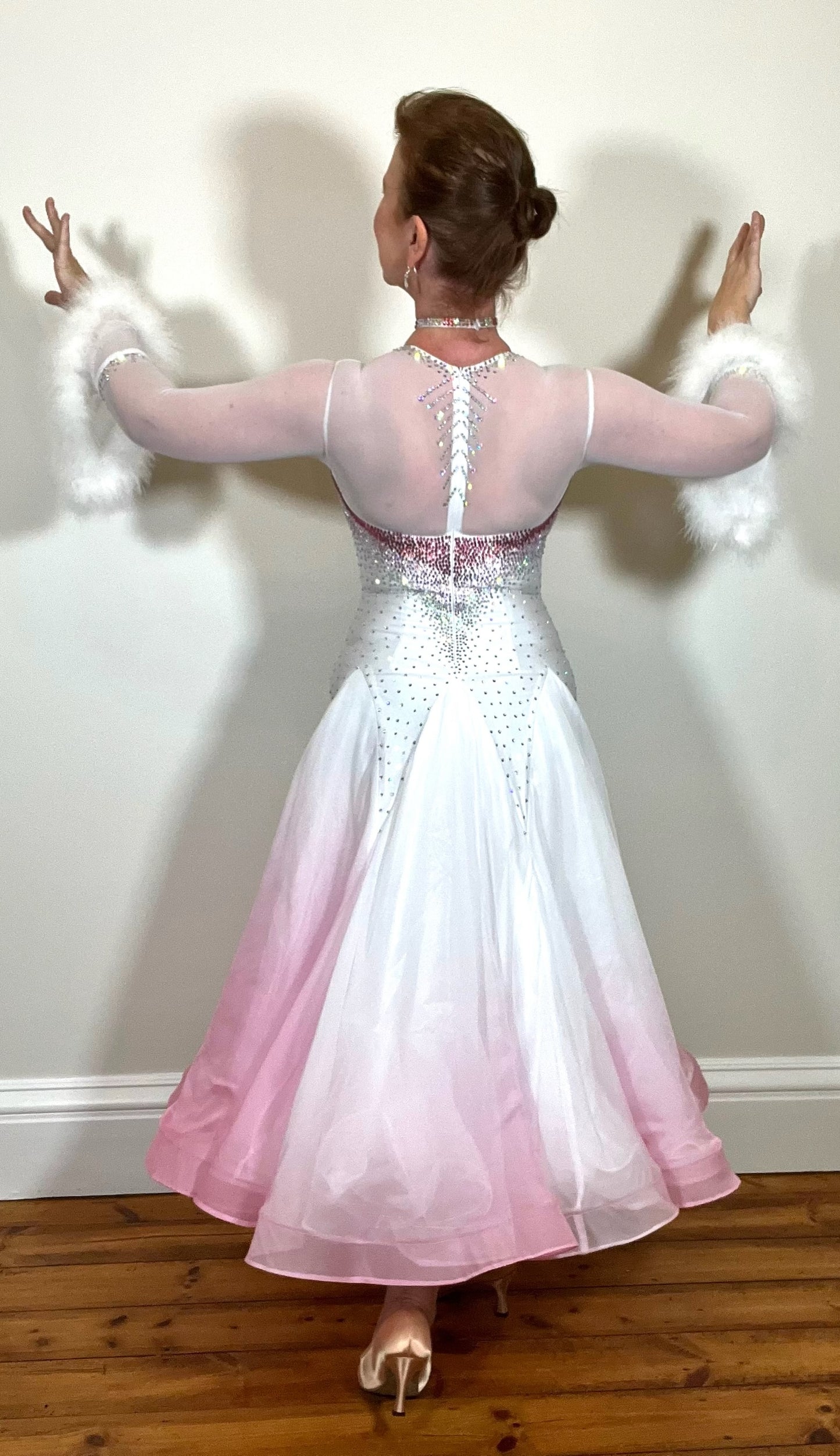 207 Pale Pink & White Ombré Ballroom Dress. Scoop neck & High mesh back. Feature stoning at the chest in rose, light rose & AB. Feather detailing to bell sleeves.